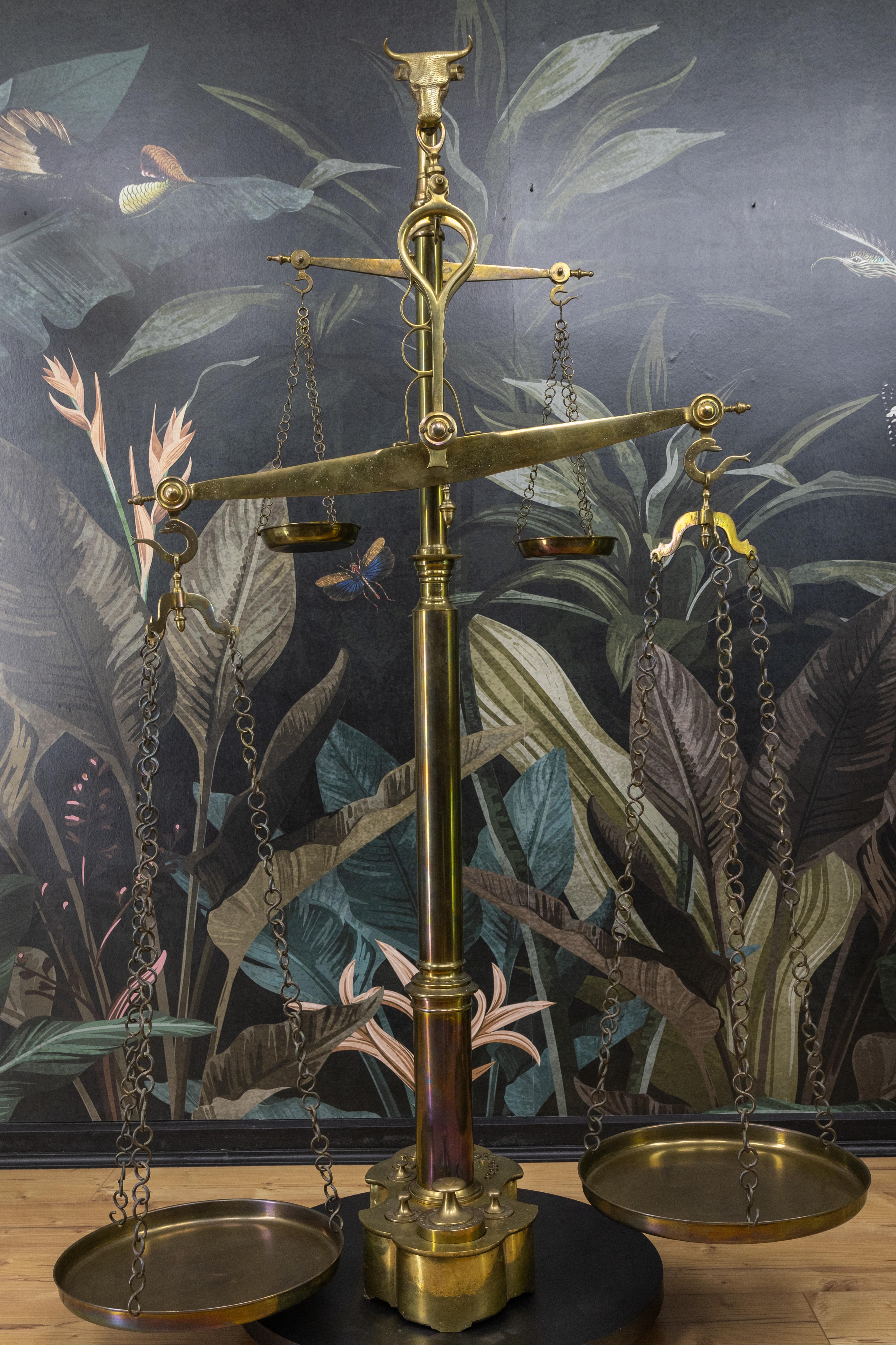 Una rara e imponente bilancia in ottone della fine del XIX secolo, attribuita a J. Motk & Co., circa 1890. Probabilmente di origine portoghese o dell'Europa centrale, questa squisita bilancia sarebbe stata utilizzata in una macelleria tradizionale o