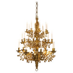Monumental antique cast and polished brass neogothical three tier chandelier