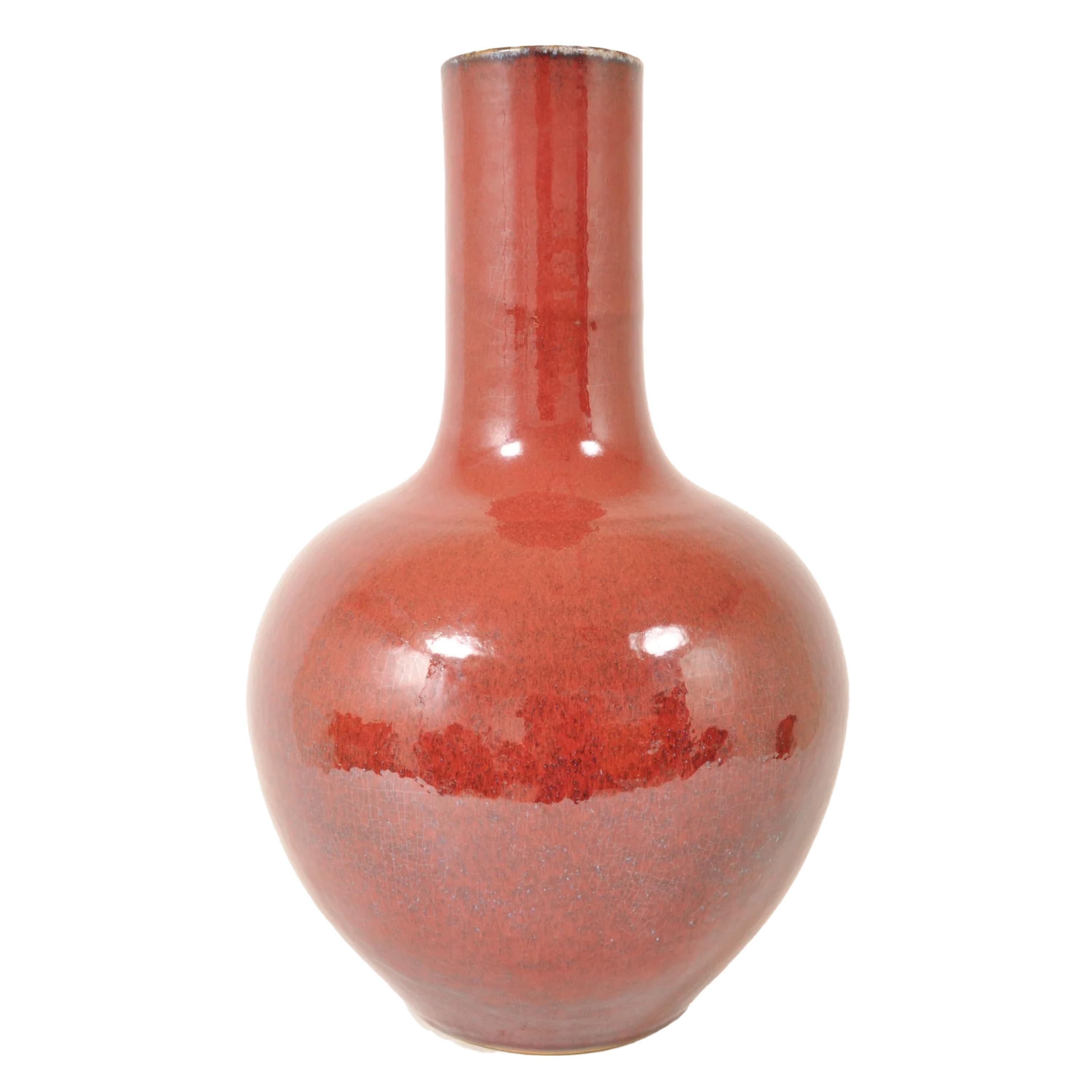 A Monumental Antique Chinese Qing Dynasty Sang de Boeuf Flambé Porcelain Vase, Circa 1890. 
The vase of monumental proportions, the globular body and tall cylindrical neck all under a Sanf de Boeuf or 'Ox Blood' colored glaze and having a mottled