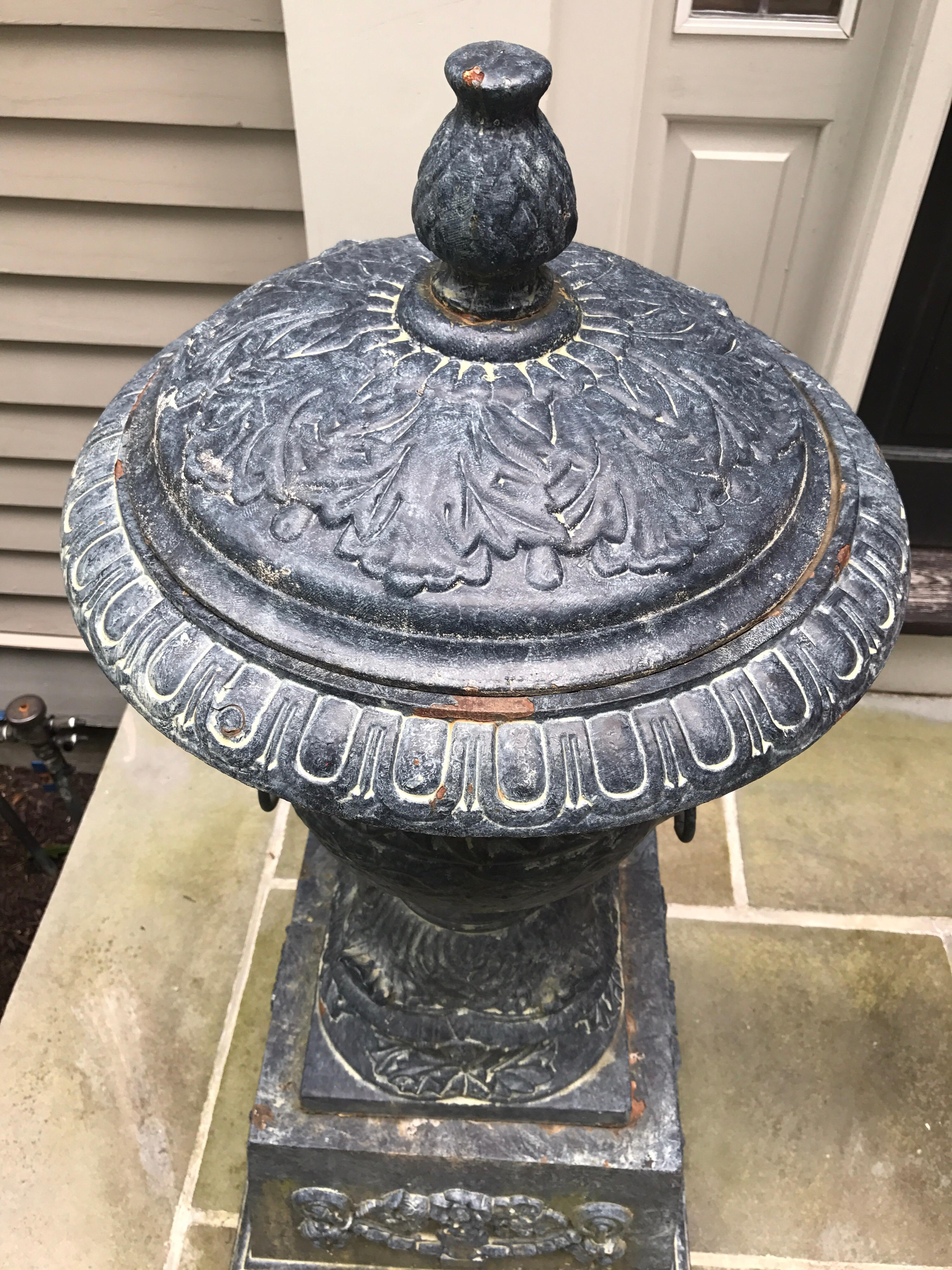 Magnificent monumental antique covered extra large cast iron urns on plinths with lion head handles,
circa 19th century, England.