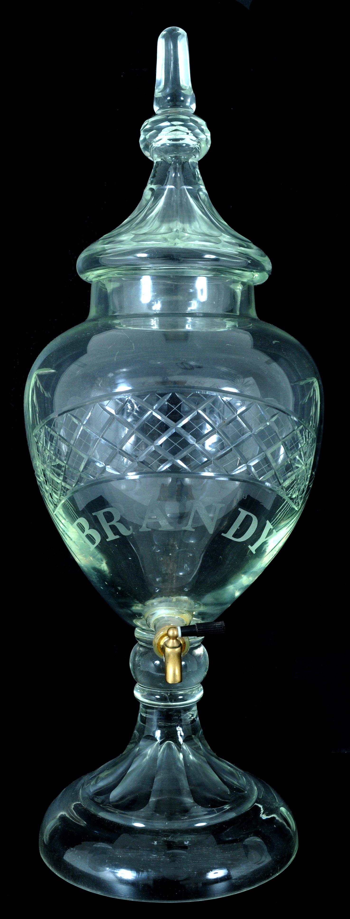 A rare Antique American crystal brandy/liquor bar dispenser, circa 1880.
The crystal dispenser is of monumental size. The lidded dispenser having a faceted lid with a cut & faceted finial above an engraved circular knop, the globular body is also