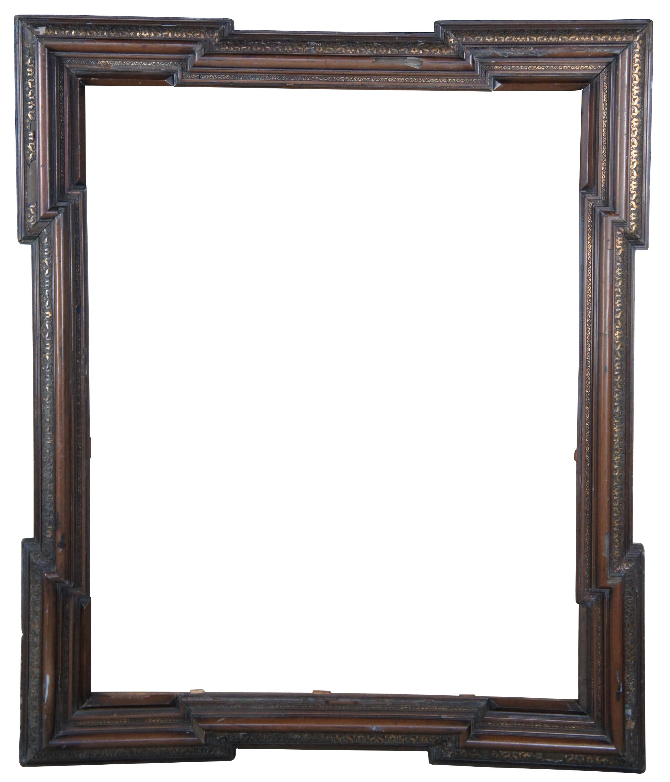Monumental antique Dutch Baroque frame. Great for use as a mirror or art frame. Made of walnut featuring geometric form with extended corners and ornate carved gilded accents over a layered frame. Measure: 61