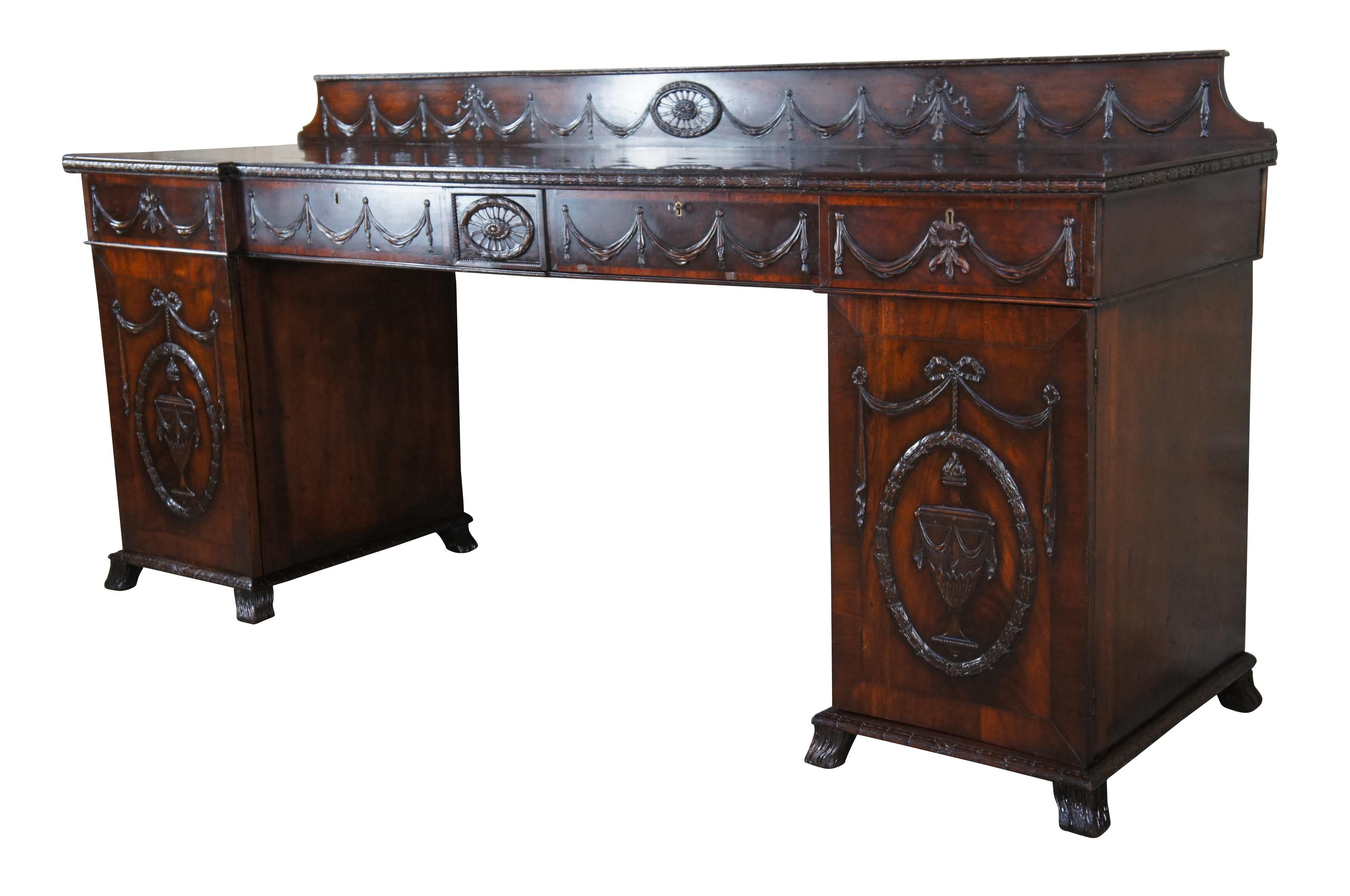 A large and impressive antique 18th century English Georgian sideboard / buffet / credenza / cabinet.  Made of mahogany featuring a  Robert Adams Neoclassical style theme of bows / ribbons / swags / rosettes / and mantel urns.  Features a double