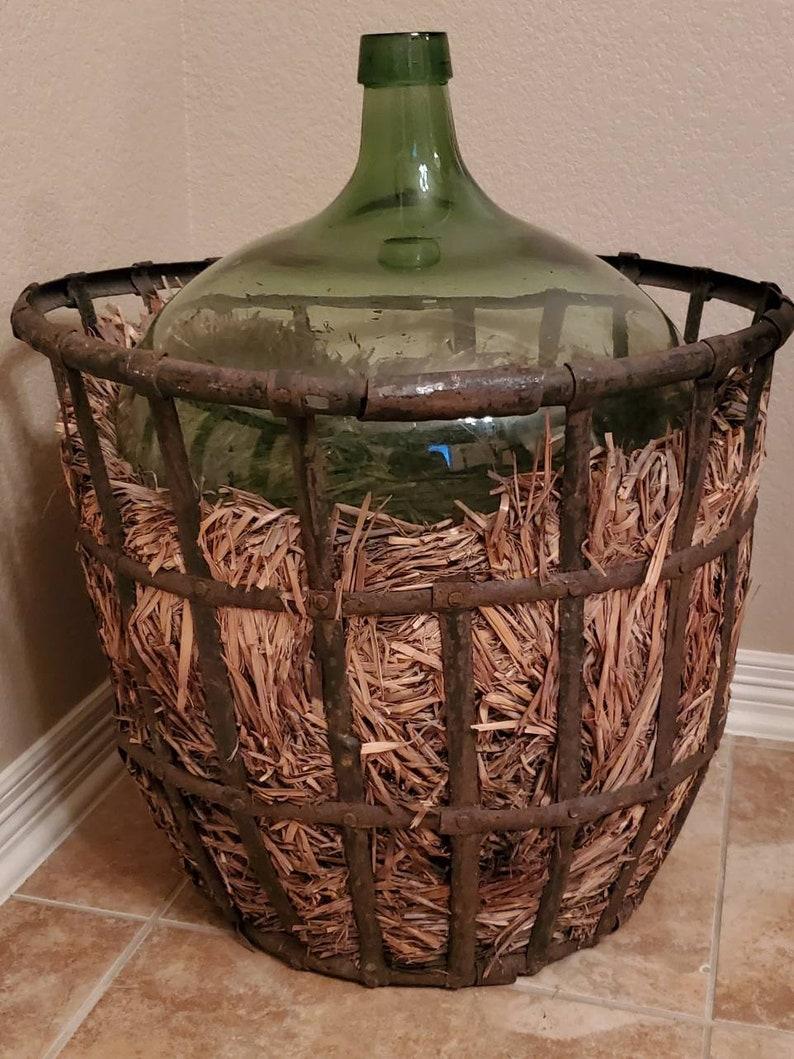 A beautiful, monumental French vineyard green glass demijohn (also known as a carboy, lady Jane or jimmyjohn) bottle (vessel, vase, jug) in a period, patinated Vintner (winemaker) iron basket, fitted with straw. Handcrafted in France in the 19th to