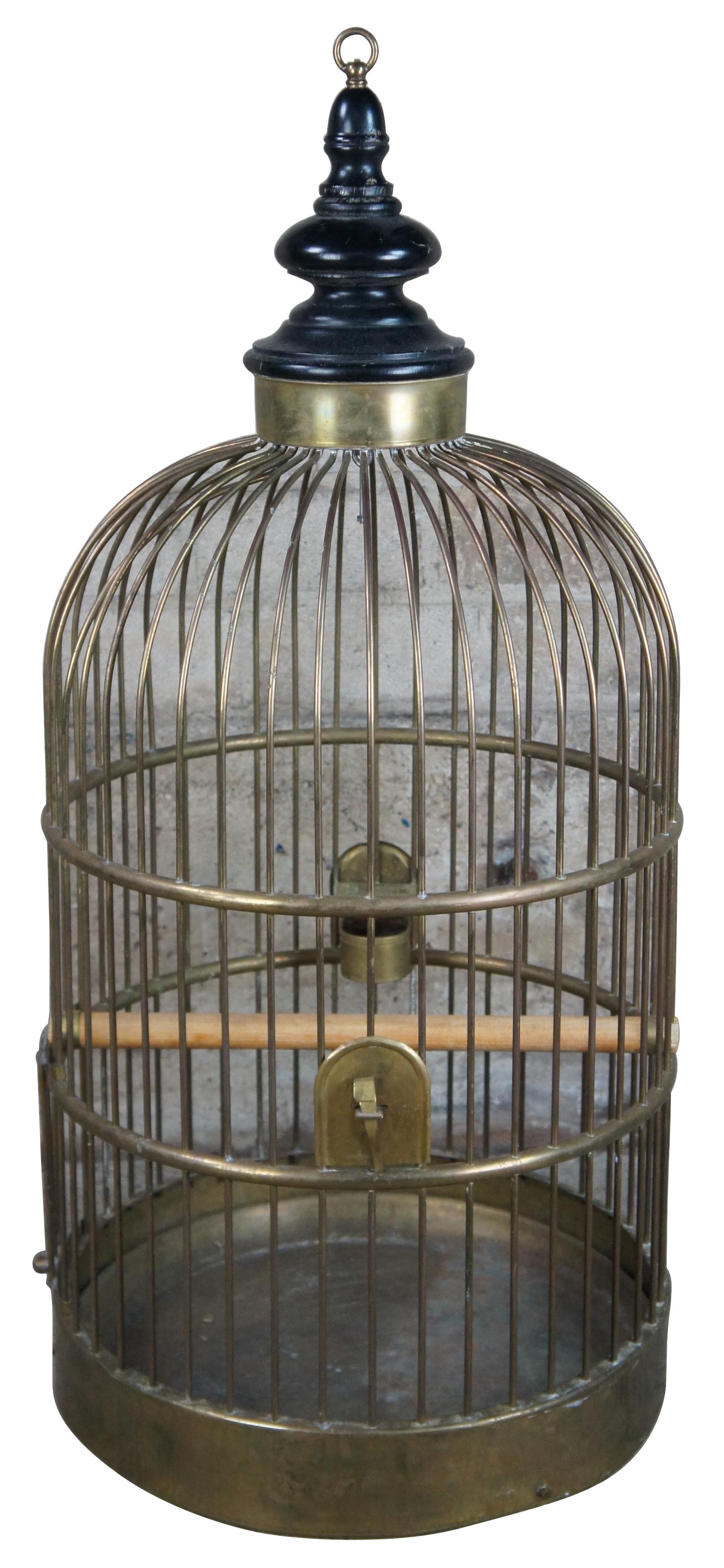 Monumental antique French bird cage featuring solid brass construction with turned wood finial, two brass feeders and perch. Measure: 39