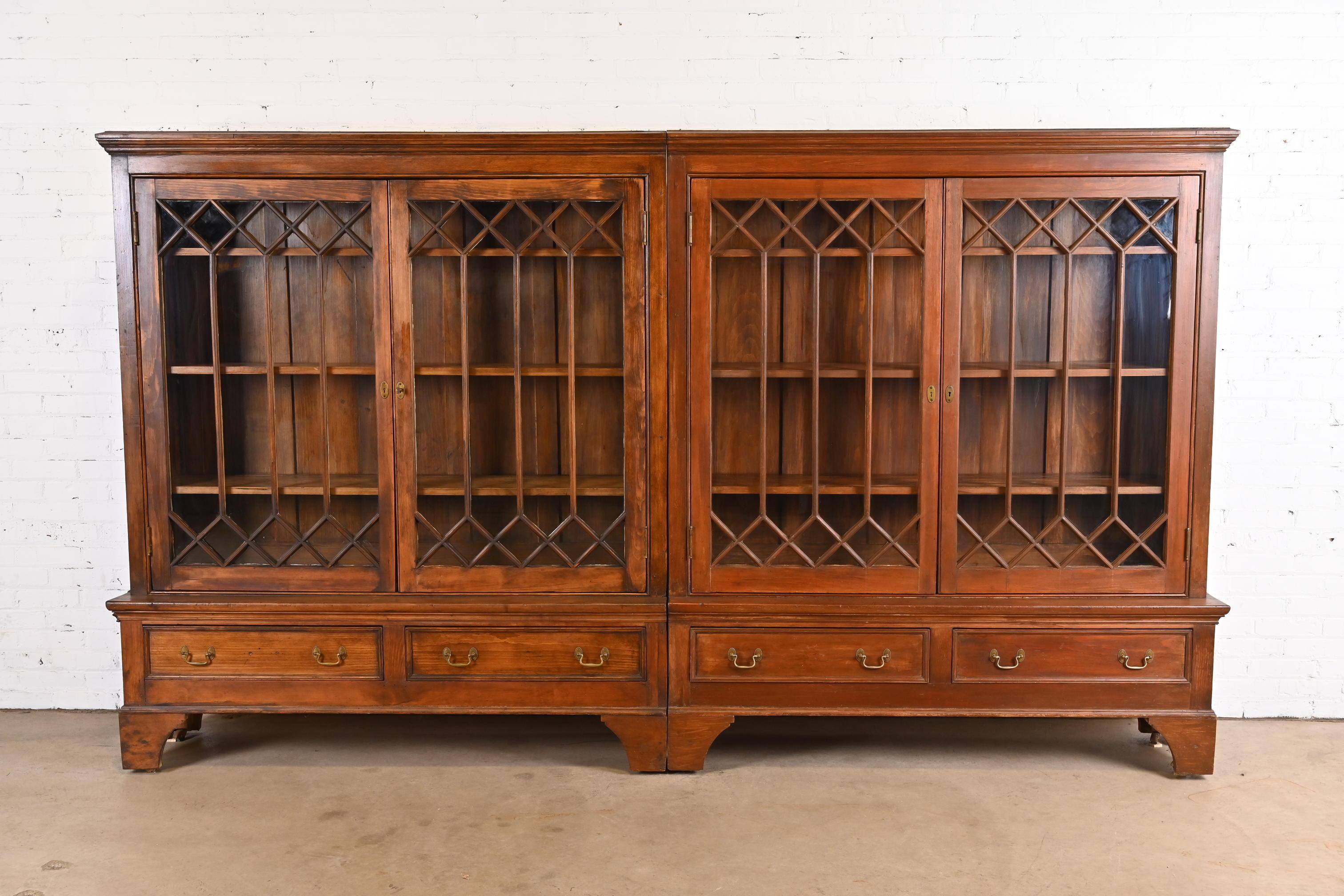 A gorgeous monumental antique Georgian or American Colonial four-door bookcase cabinet

USA, Circa 1900

Solid carved pine, with mullioned glass front doors, step back base with four drawers, and brass hardware.

Measures: 124.25