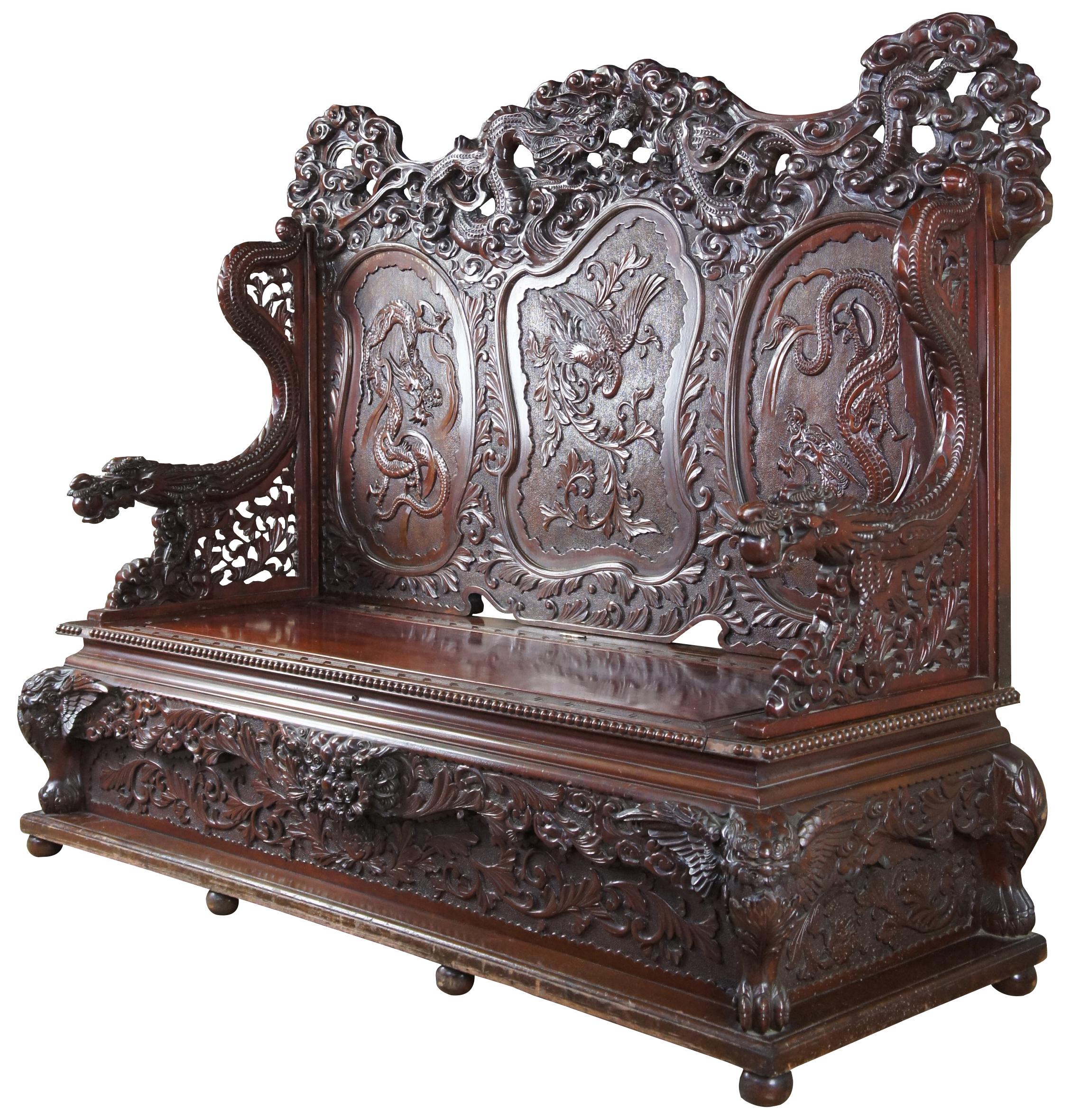 Imperial Japanese Meiji Period dragon bench. Features high relief carved accents and under seat storage. From top to bottom this piece is ordained with three toed dragons. The crown is pierced with a serpentine dragon sprawling through a field of