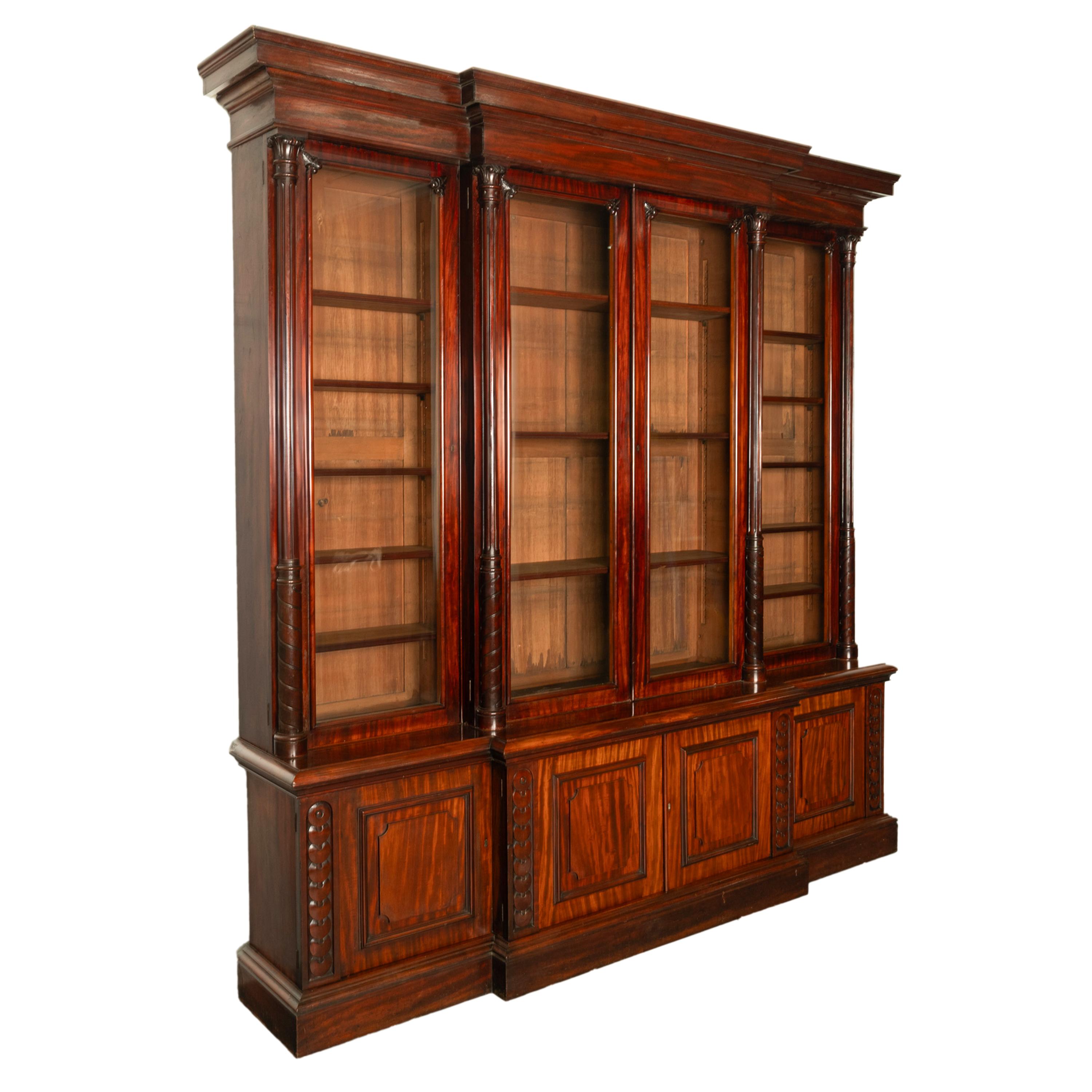 A very stately & monumental antique Irish mahogany breakfront bookcase/bibliotheque, circa 1850.
The bookcase of break-fronted form disassembles into five sections for ease of movement, to the top is a stepped cornice with four glazed doors below,