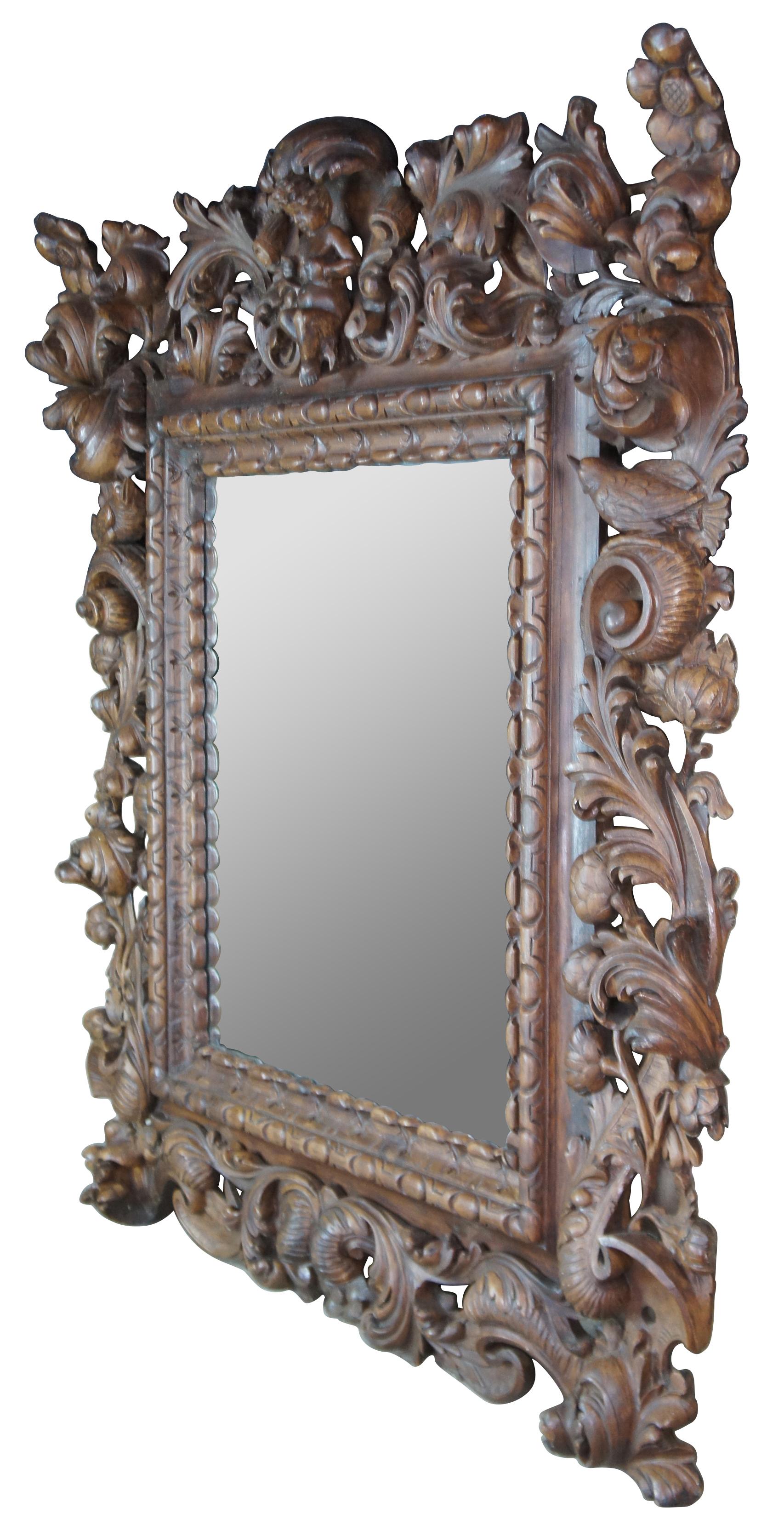 Impressive monumental Italian baroque or rococo wall mirror. Made of hard wood with rectangular form featuring heavy high relief / reticulated carvings of a cherub flanked by two birds with scrolled flowers and acanthus leaves. Measure: 74