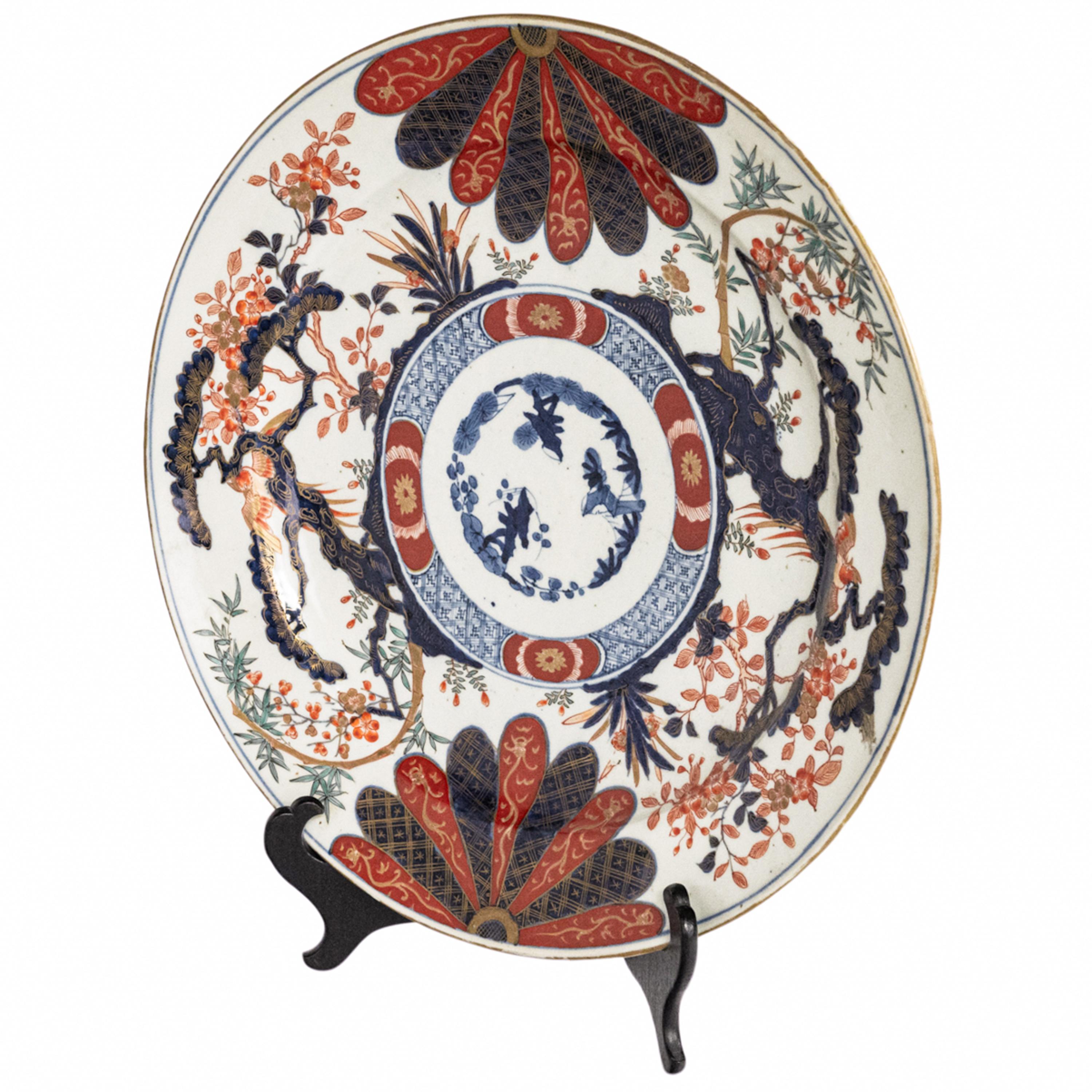 Fino y monumental plato/cargador de porcelana japonesa del periodo Meiji, hacia 1890.
El cargador está finamente decorado con vidriado azul bajo vidriado, óxido de hierro rojo y realzado con decoración dorada.
En el centro del cargador hay círculos