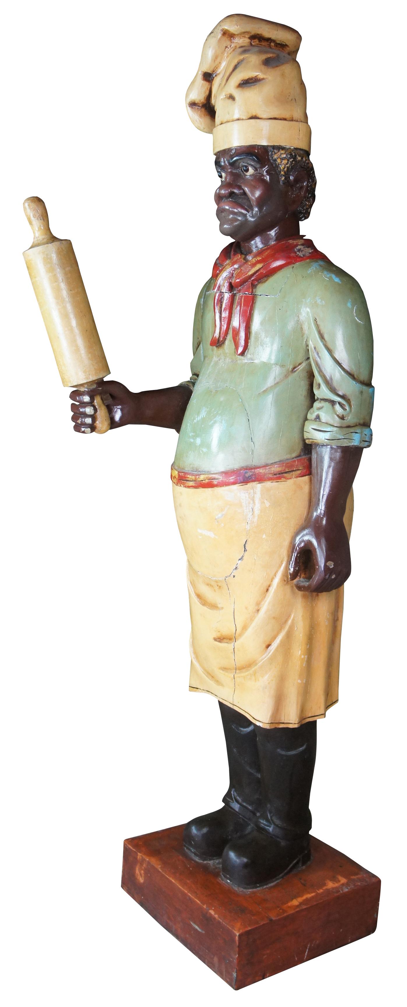 Monumental antique life size chef or baker statue. Carved of wood in the style of a cigar store figure, featuring a tall chef with traditional French kitchen attire holding a rolling pin. Acquired in France in the 1980s from an old restaurant where