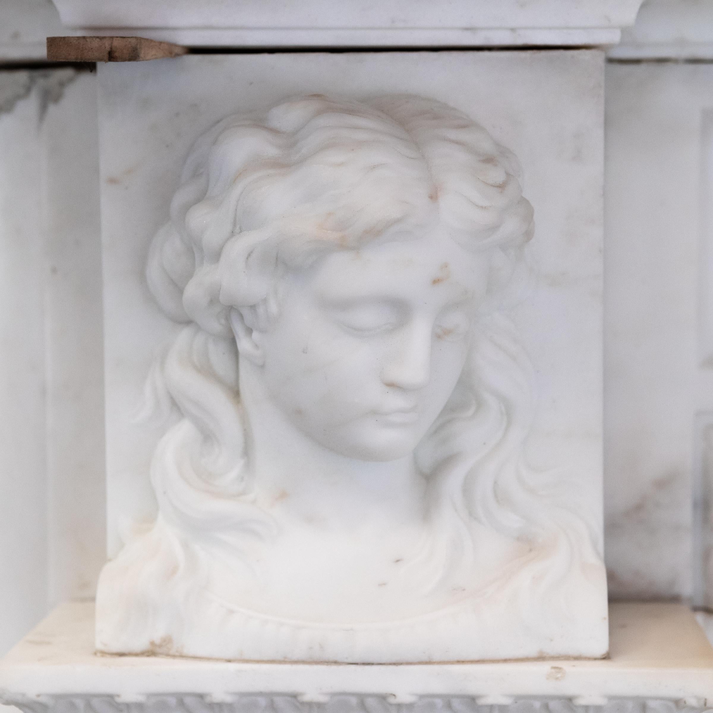 An exceptional 19th Century English Statuary marble fireplace.

The large surround has finely carved masks to the top of each jamb, and is surmounted by a deep bevelled shelf. 

Delicately carved floral paterae decorate the frieze. Fluted jambs ret