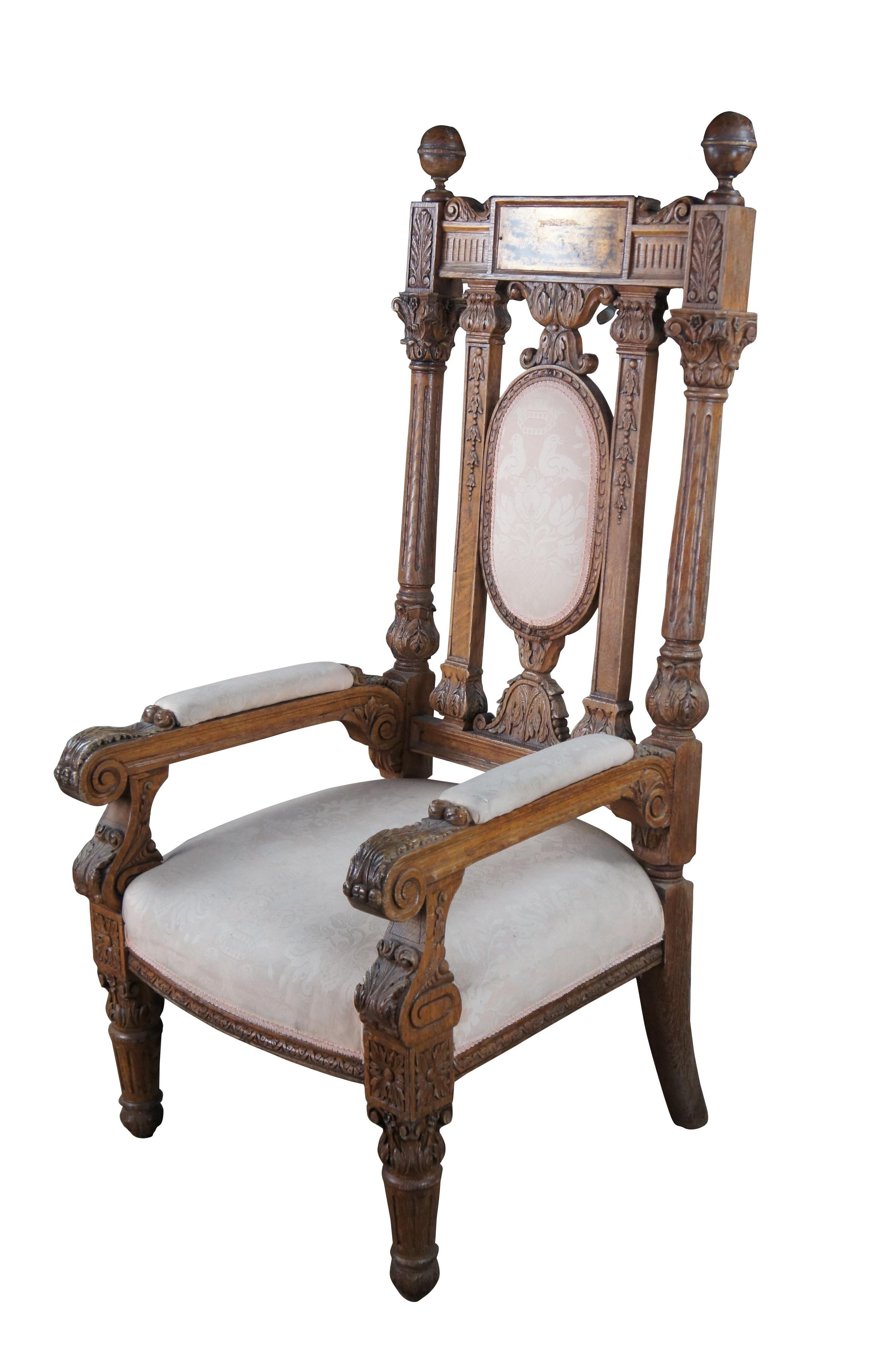 Monumental antique Victorian throne armchair.  Made of oak featuring ornate reticulated design with highly carved foliate / floral motif throughout.  The crest features large turned finials that flank a brass name plaque which sits above fluted