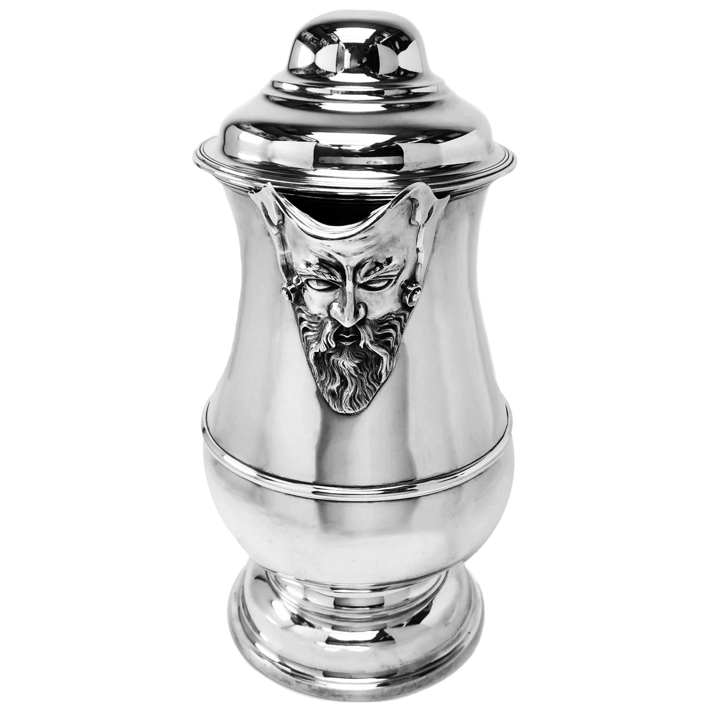 A magnificent oversized Antique Victorian Silver Flagon in the style of a Georgian Silver Ale Jug. This Ale Flagon has a classic baluster shaped form and stands on a domed pedestal foot. The Flagon has an impressive chased face embellishing the