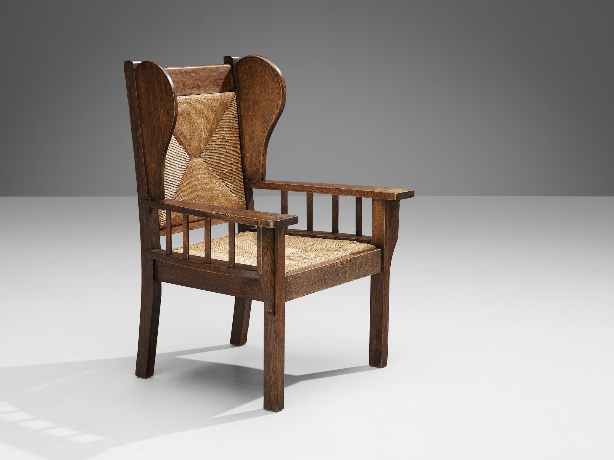 Armchair, oak, rush, Europe, 1940s 

Monumental armchair in oak with a strong presence and appearance. This stately piece is executed in oak and rush and was made in Europe in the 1940s. Its broad armrests and the subtle winged back create this
