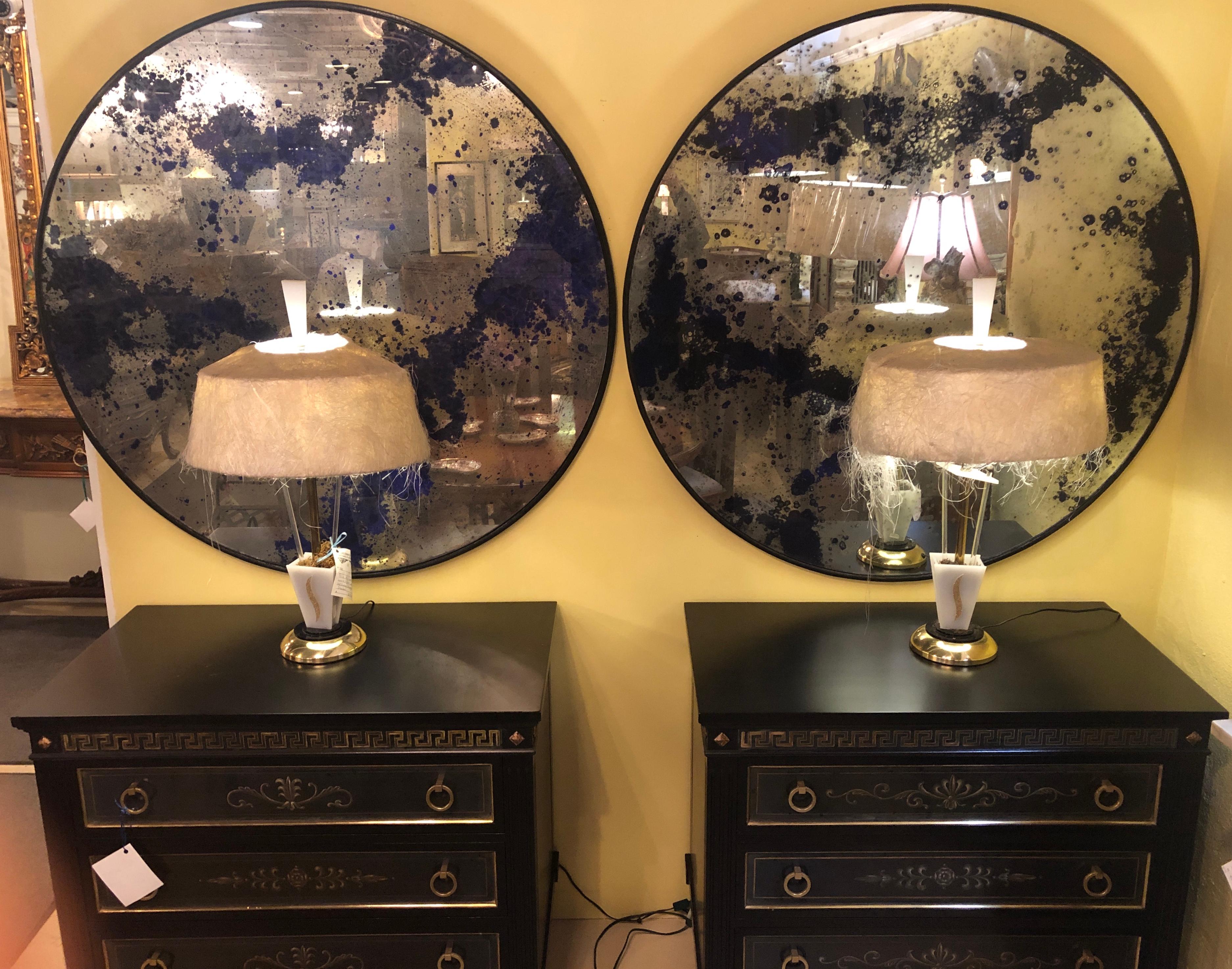 A fine custom pair of monumental Art Deco circular black and silver gilt distressed wall or console mirrors that can be used as table tops for any center or end tables. Each large and impressive mirrored frame highly distressed and speckled in ebony