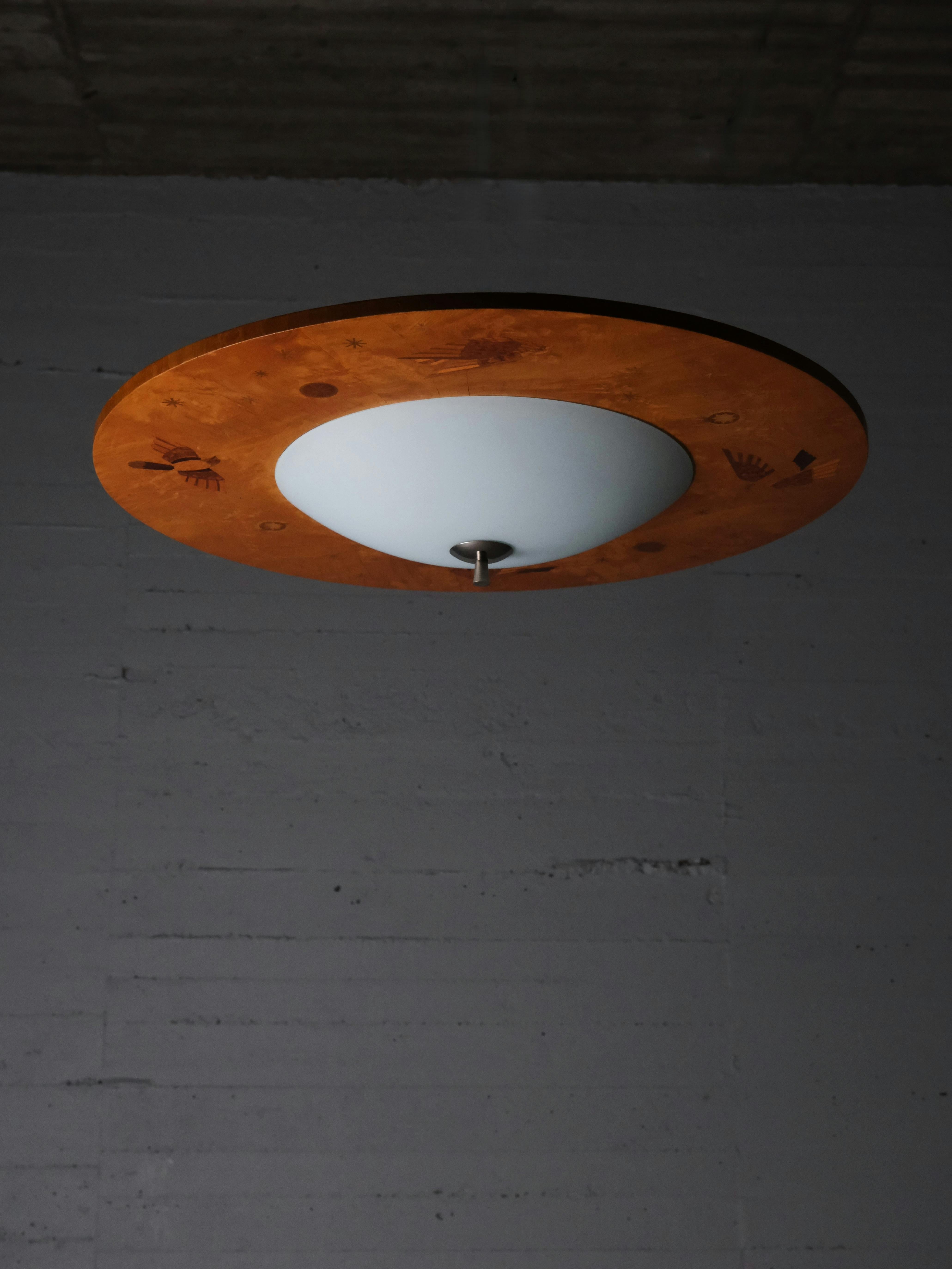 Impressive flush mount ceiling lamp designed by Birger Ekman for Mjölby Intarsia during the 1930s. 

Beautiful wood inlays.