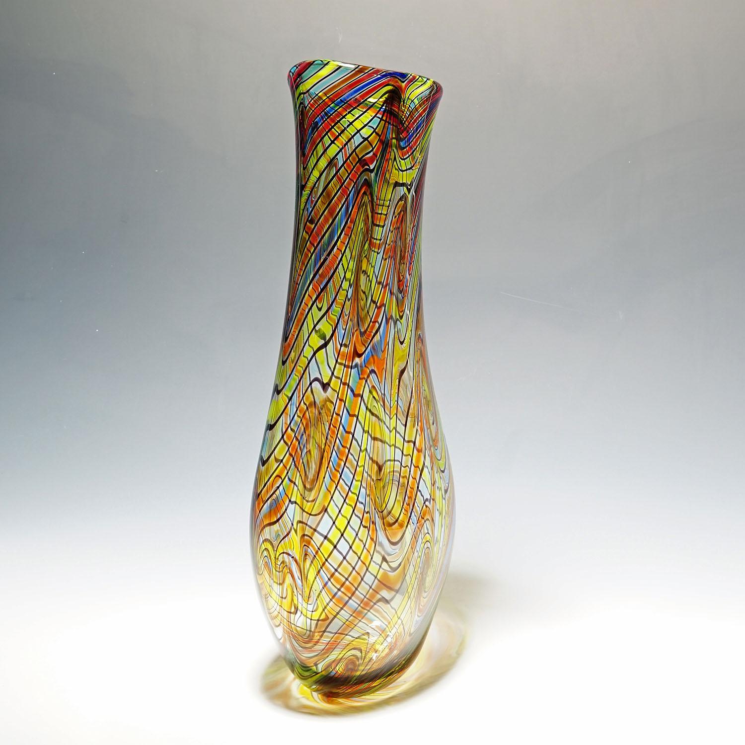 Monumental art glass vase by Luca Vidal, murano.

A large art glass vase handmade by glass master Gianluca Vidal early 2000s. Free formed clear glass body internaly decorated with colorful treads drawn in waves. Signed with 'Vetro Artistico Murano'