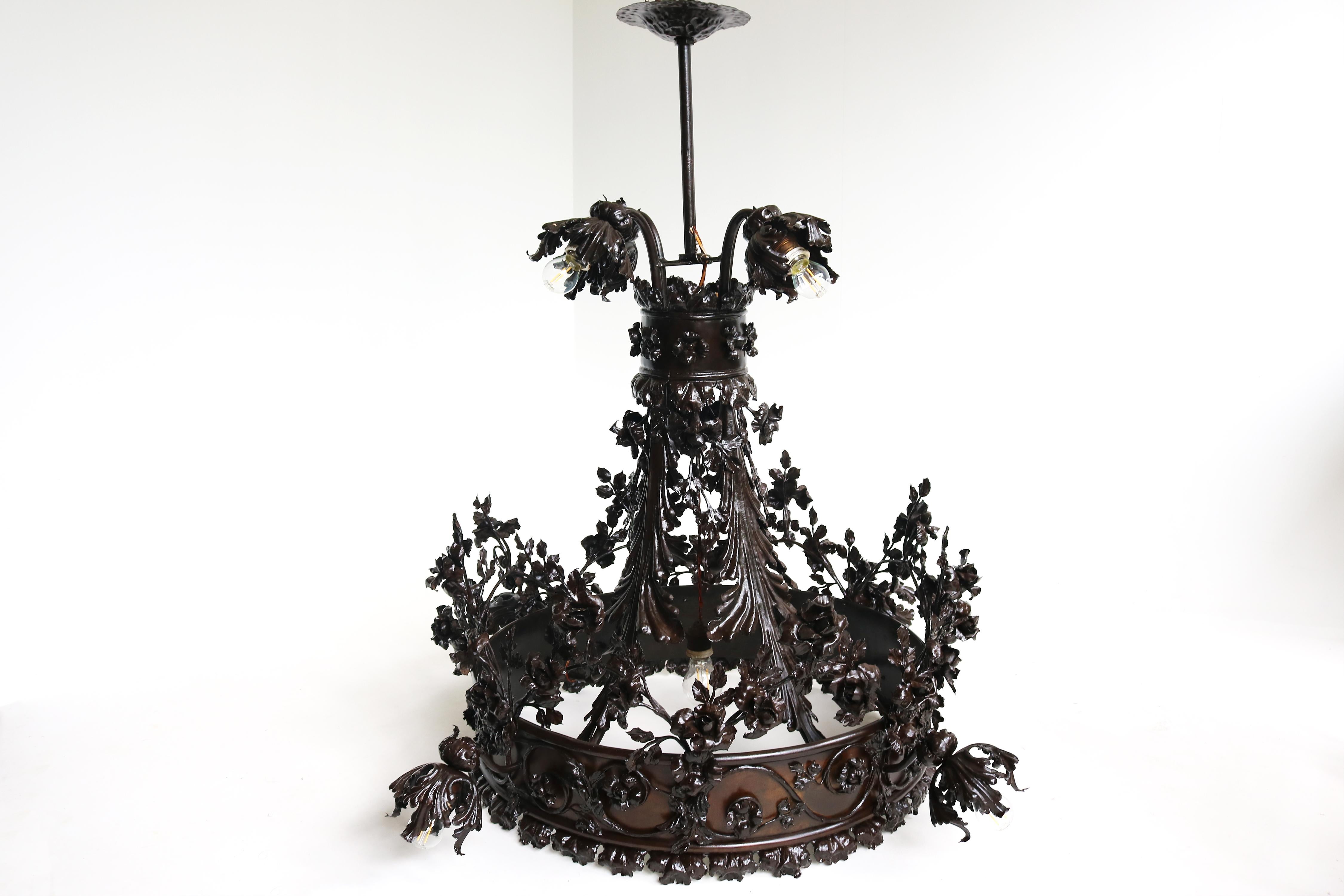 Molto grande e di grande effetto! Questo lampadario monumentale in ferro battuto attribuito all'artista Louis Van Boeckel (di Lier,  Belgio, 1857-1944)  con le sue caratteristiche rose, fu uno dei più importanti fabbri ornamentali del suo tempo.