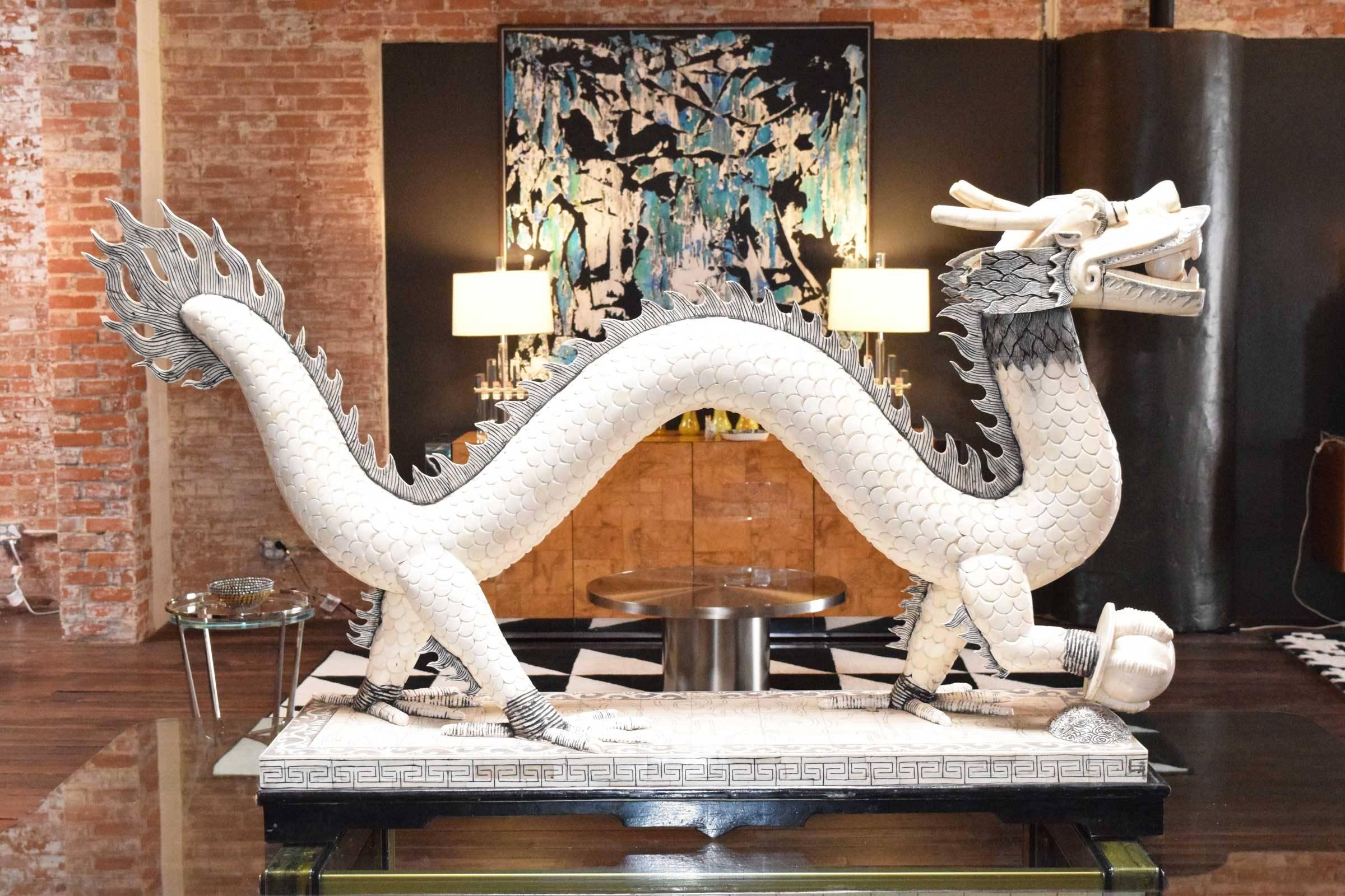 Over 5 feet long and 3 feet high, this is a beautifully crafted dragon made of bone. This is a five claw dragon with horns. The details are very ornate. Dragon's foot is holding a pearl and there is a ball in his mouth. 

East Asian dragons are