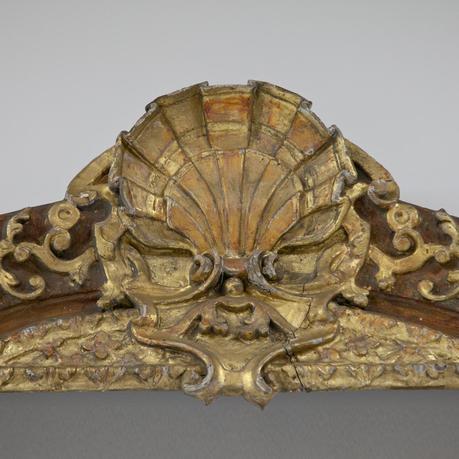 Monumental Baroque frame with a crowning shell ornament at the top and iron mounts at the bottom. The partly gilt stucco frame is wavy and shows scrollwork ornaments as well as flowers in the corners and on opposite sides. Inner dimensions: circa