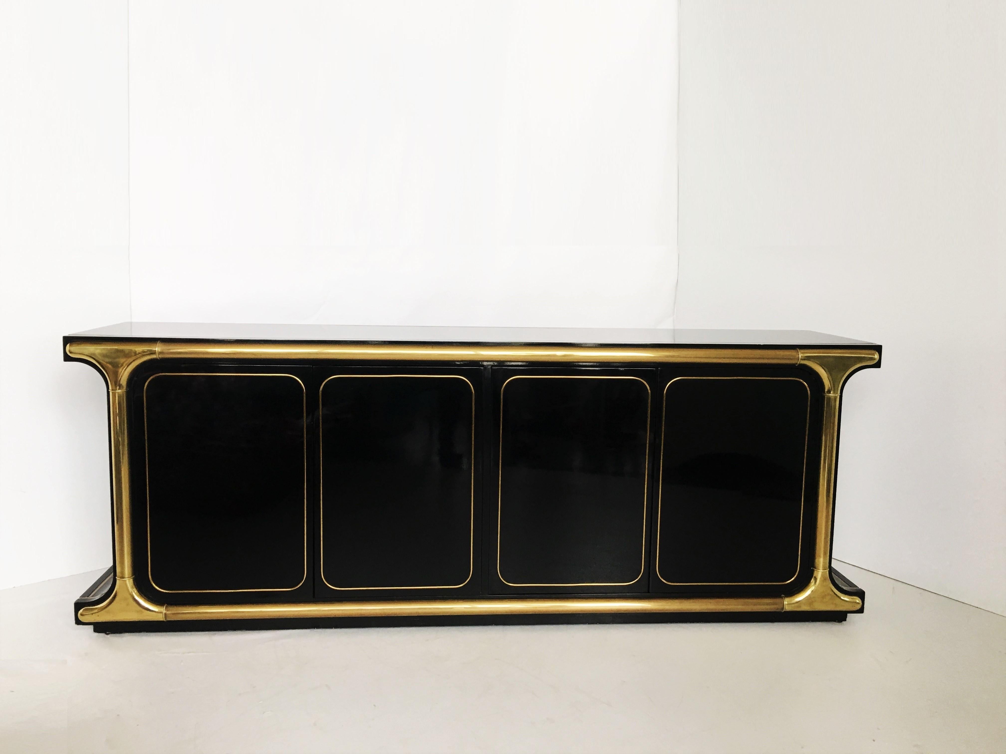 Glamorous one-of-a-kind piece designed by the great Mastercraft in Grand Rapids. Features a black lacquer body, both sides have a gentle curve. Substantial brass trim pieces and graphic brass inlays. Each side has a pair of touch-latch doors that