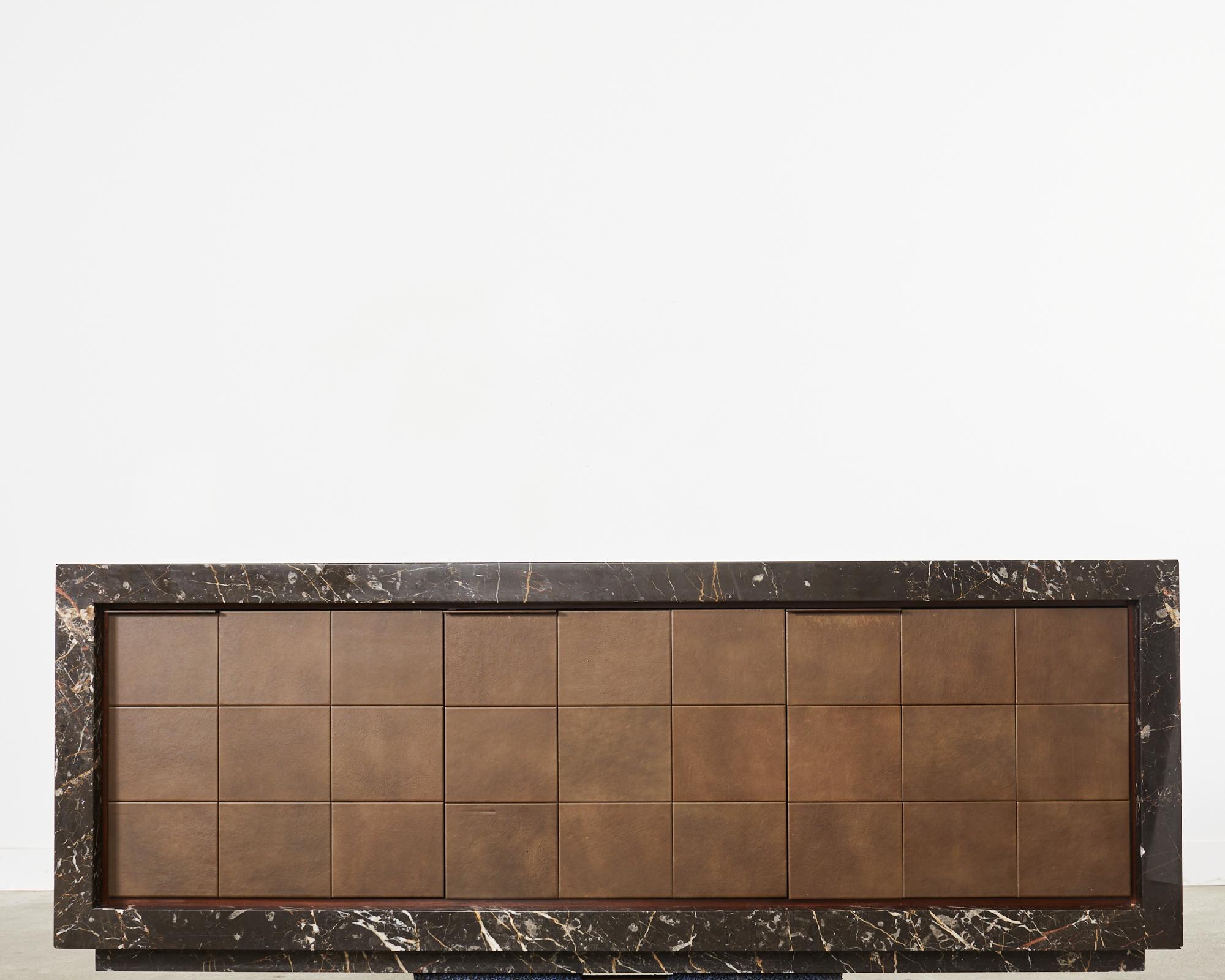 Bespoke monumental sideboard or credenza crafted from black marble appearing as a solid block case. The imposing credenza is incredibly heavy and solid weighing an estimated 800 pounds. Finished on all sides fronted by geometric leather clad