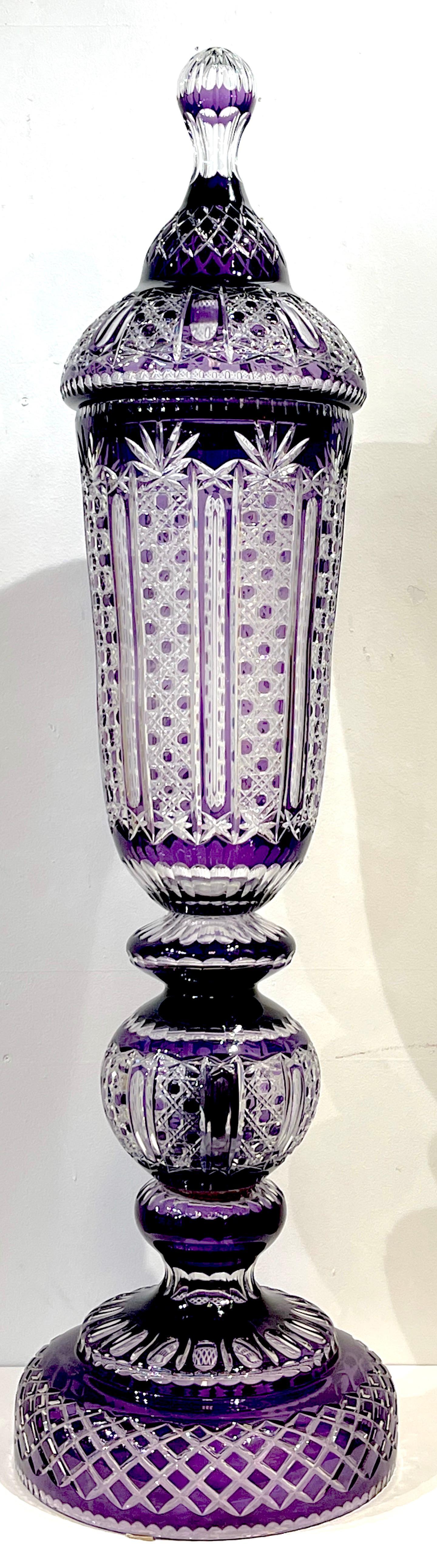 Monumental Bohemian amethyst cut to clear palace vase. Impressive well proportioned scale, in three parts, with brilliant color and cutting.
Standing 56 inches high x 14.5 inch middle diameter and 16 inch diameter base.
Lid measures: 12