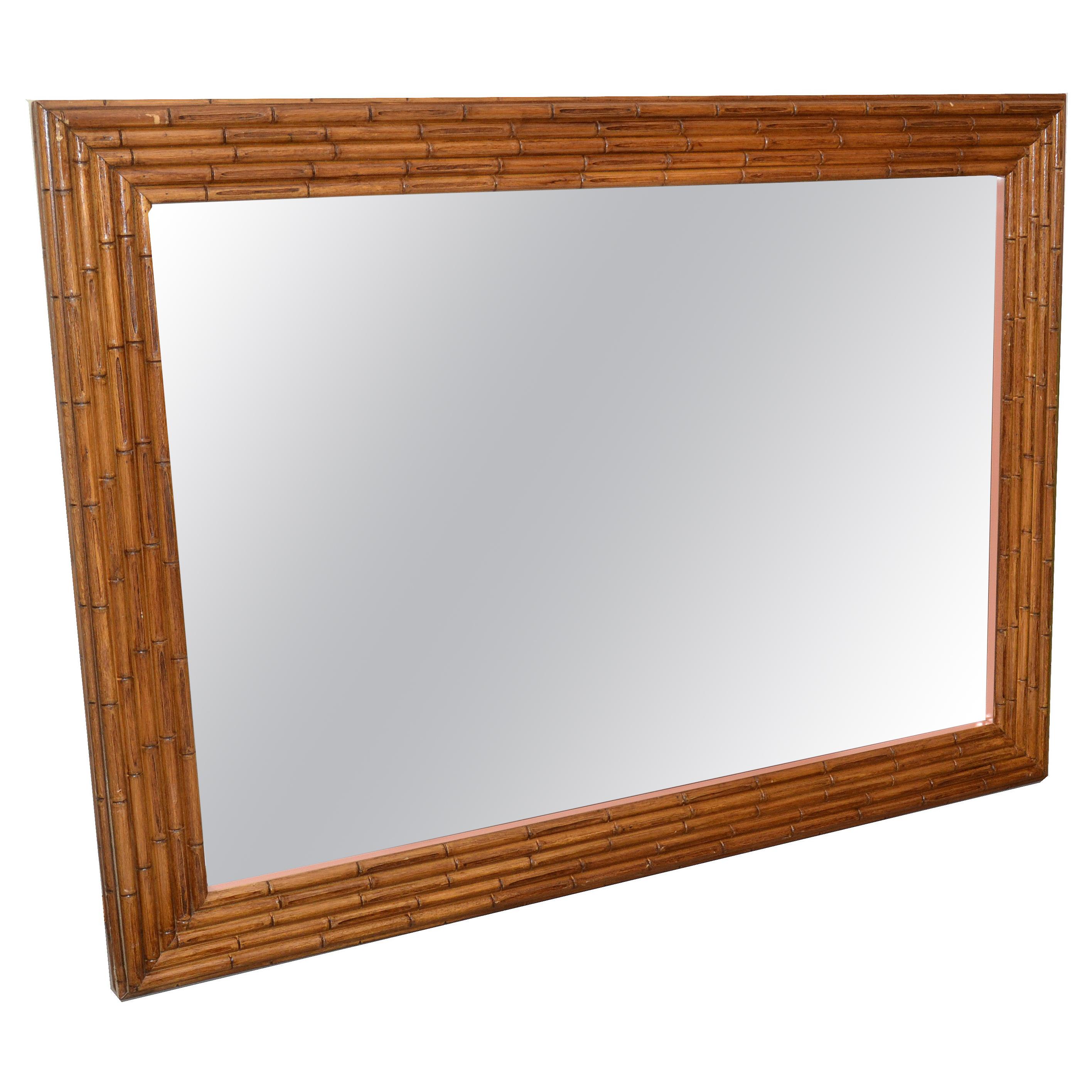 1950s Bohemian Chic large and heavy rectangular wall or dresser mirror made out of Bamboo. 
The mirror is very heavy and is supported by a wooden backing for secure hanging.
American craftsmanship in its best.
Can be used as single wall mirror or