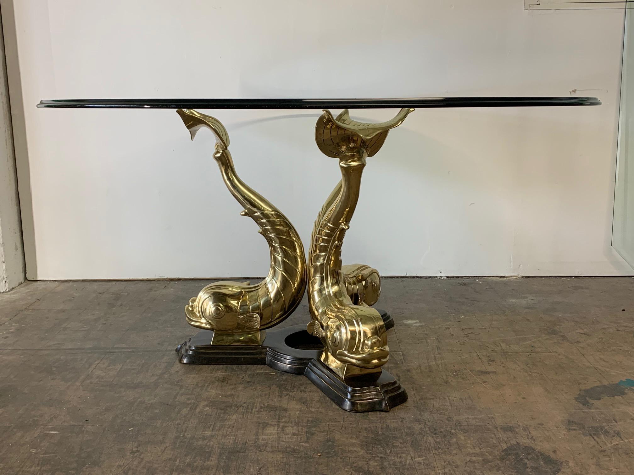 Freshly restored brass Asian dolphin pedestal dining table features three majestic fish (also considered Koi) mounted on a bronze base with a thick 60