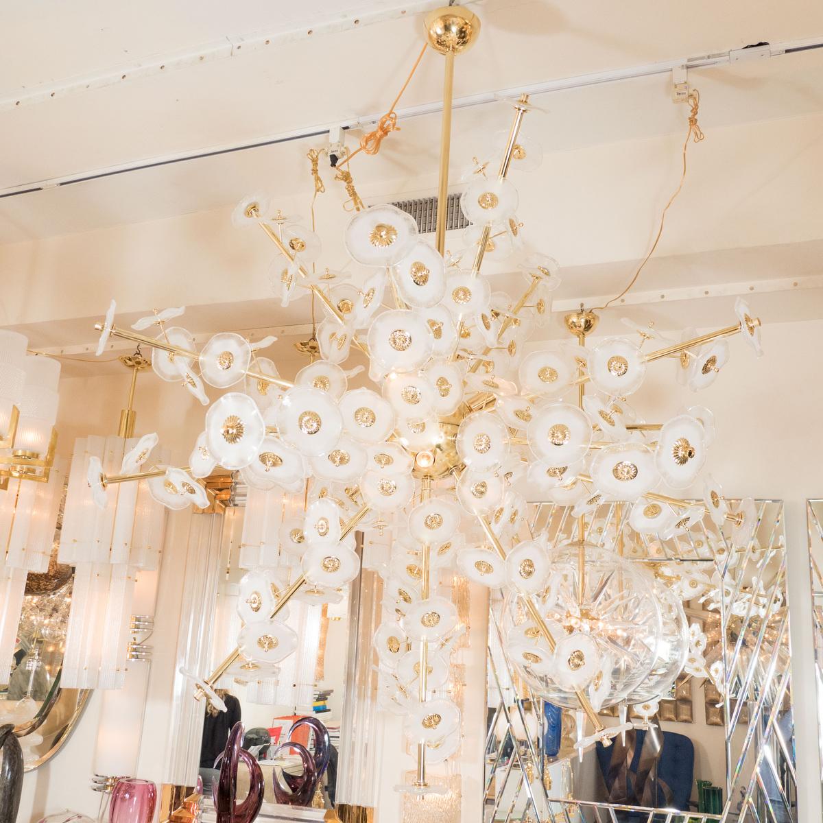 Monumental brass flower burst chandelier featuring frosted glass blossoms designed by John Salibello.