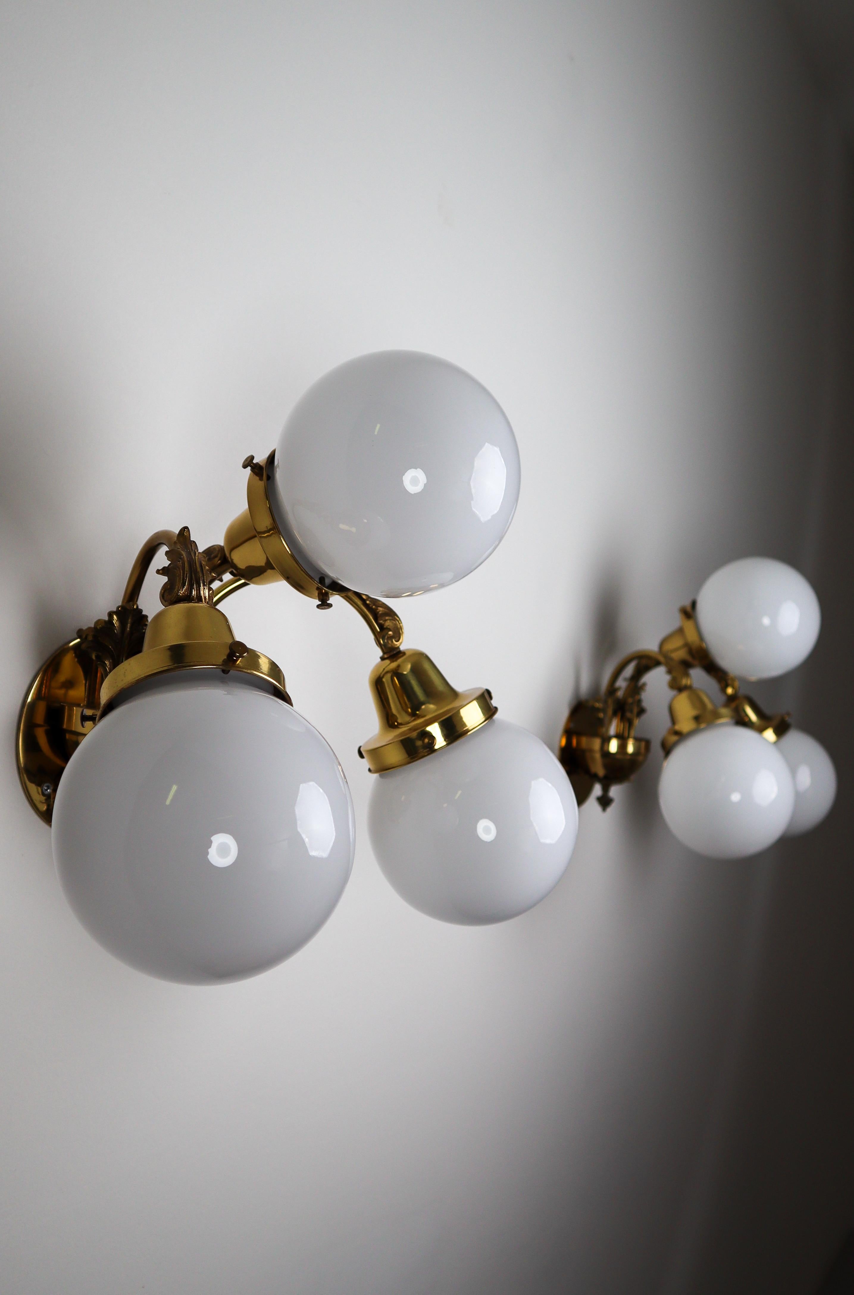 Monumental brass wall lights with opaline glass globes from the National Gallery Praque.

Monumental and chic design wall lights with high quality brass fixture and luxury opaline glass globes. These wall lights with brass frame consist of three