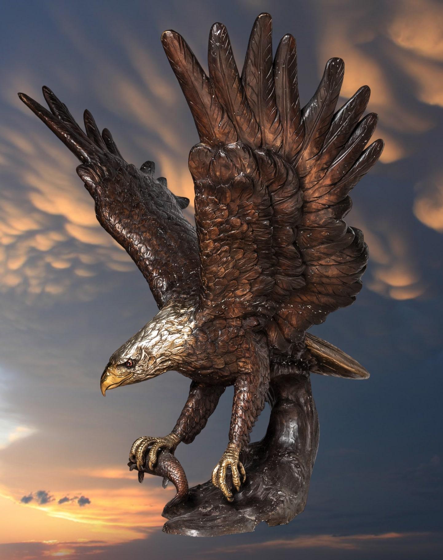 Monumental bronze eagle sculpture. The majestic bird lands on a tree branch after a successful hunt with prey in his right claw. The detail and finish of this piece are exceptional.