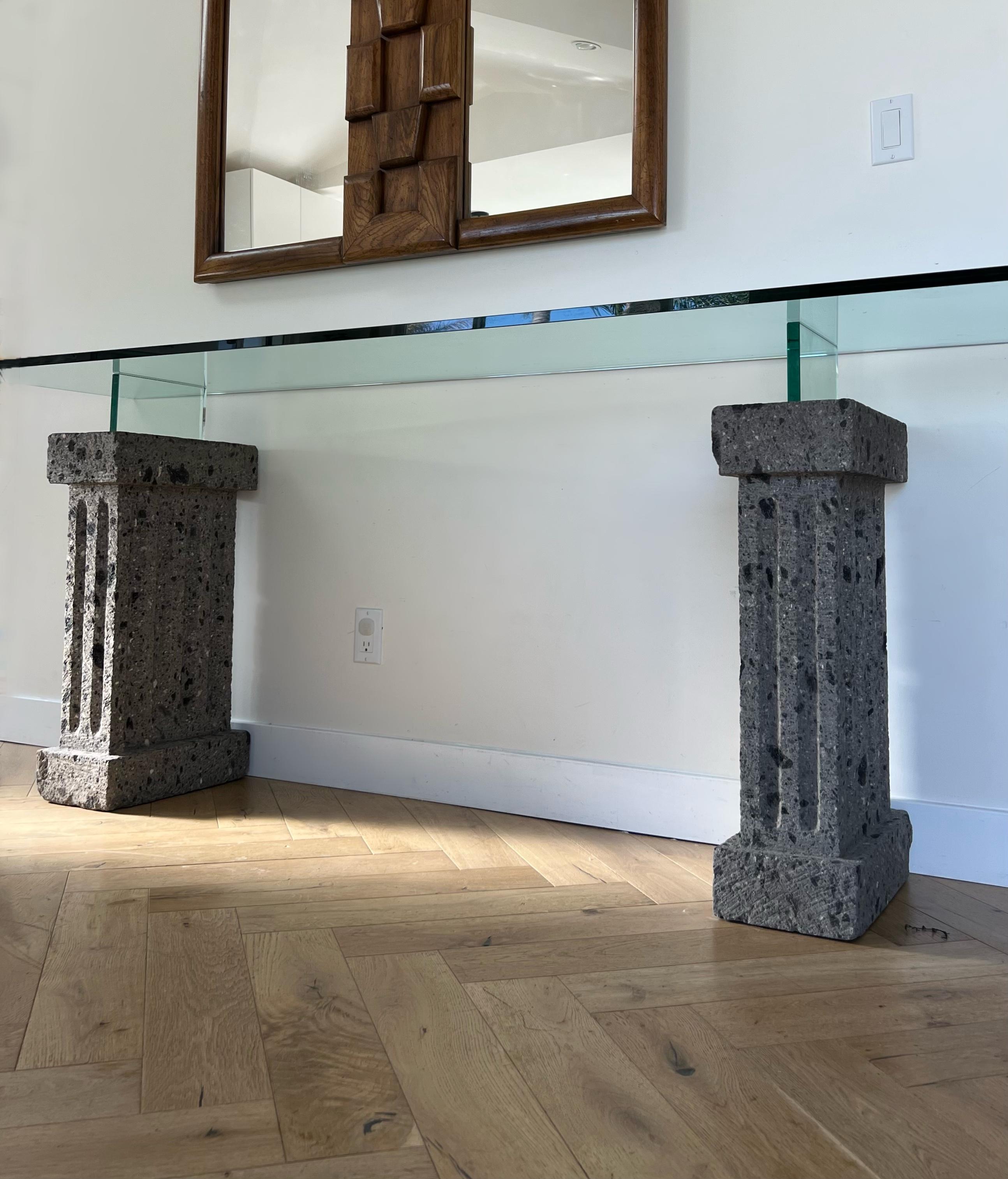 A monumental seven foot long brutalist console table of rock and glass, circa 1970s, with exceptional provenance: this piece hails from the Japanese consulate of Vancouver. Also combining postmodern and neoclassical sensibilities, two stone bases