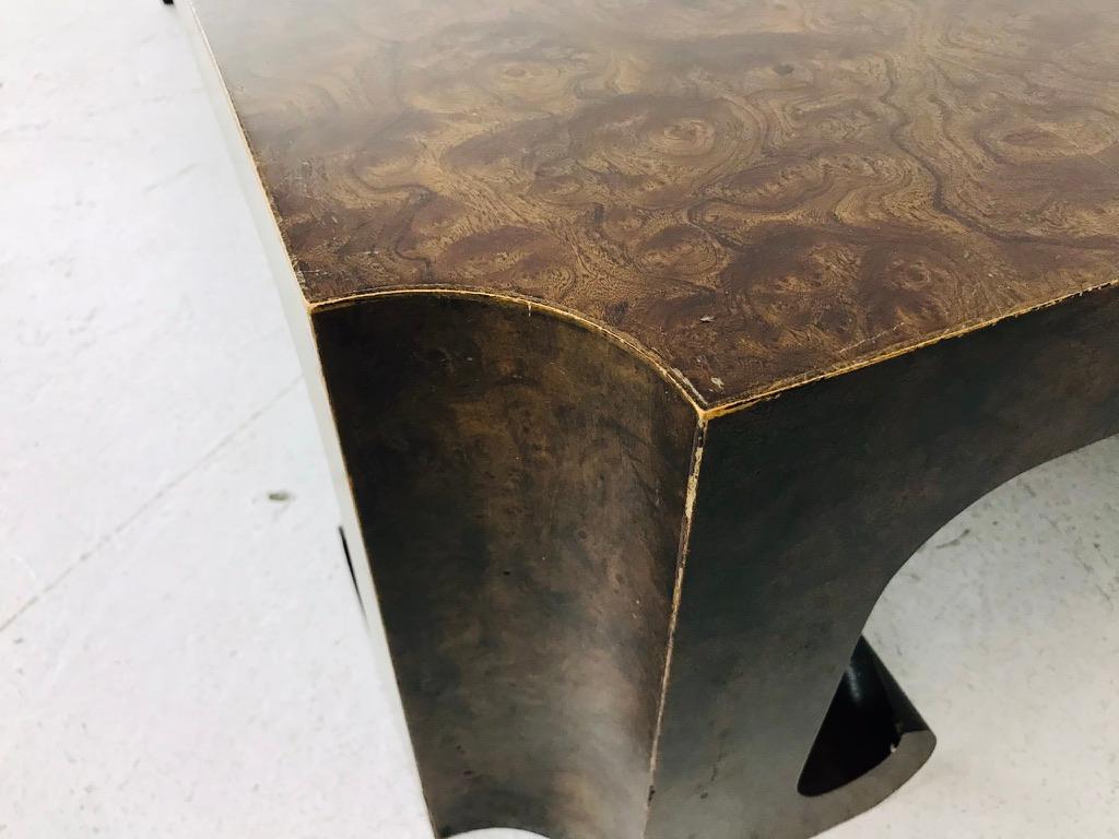 Handsome, oversized burl wood coffee table by Baker Furniture. Table has beautiful Asian influenced lines with scalloped corners, chunky legs, and curled feet. Table would be excellent in a Hollywood Regency, Mid-Century, transitional, or modern