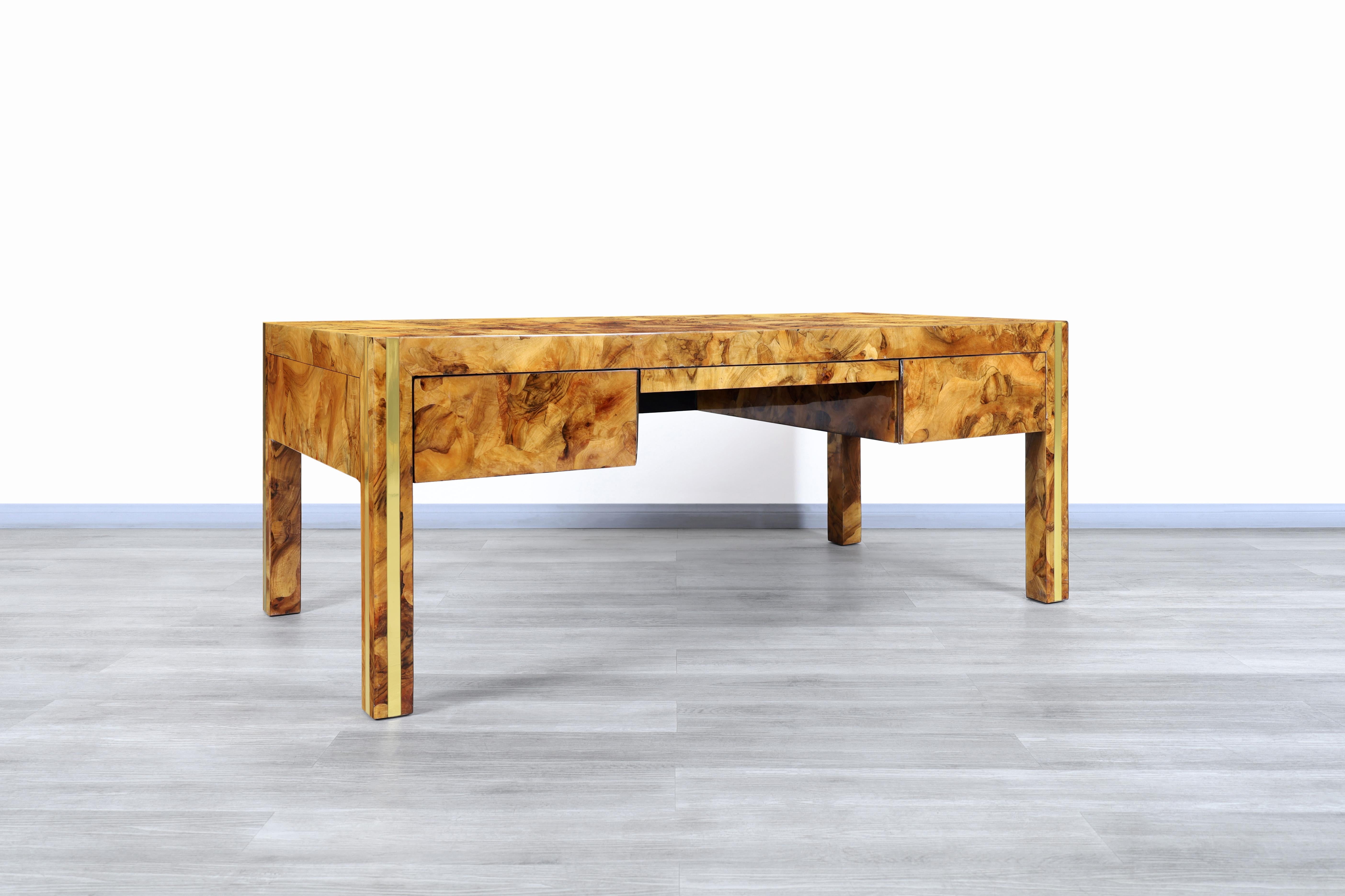 Fabulous monumental vintage burl wood and brass executive desk designed and manufactured in the United States, circa 1970s. This desk is extremely attractive to any viewer due to the versatility of the design and the elegance of the materials used