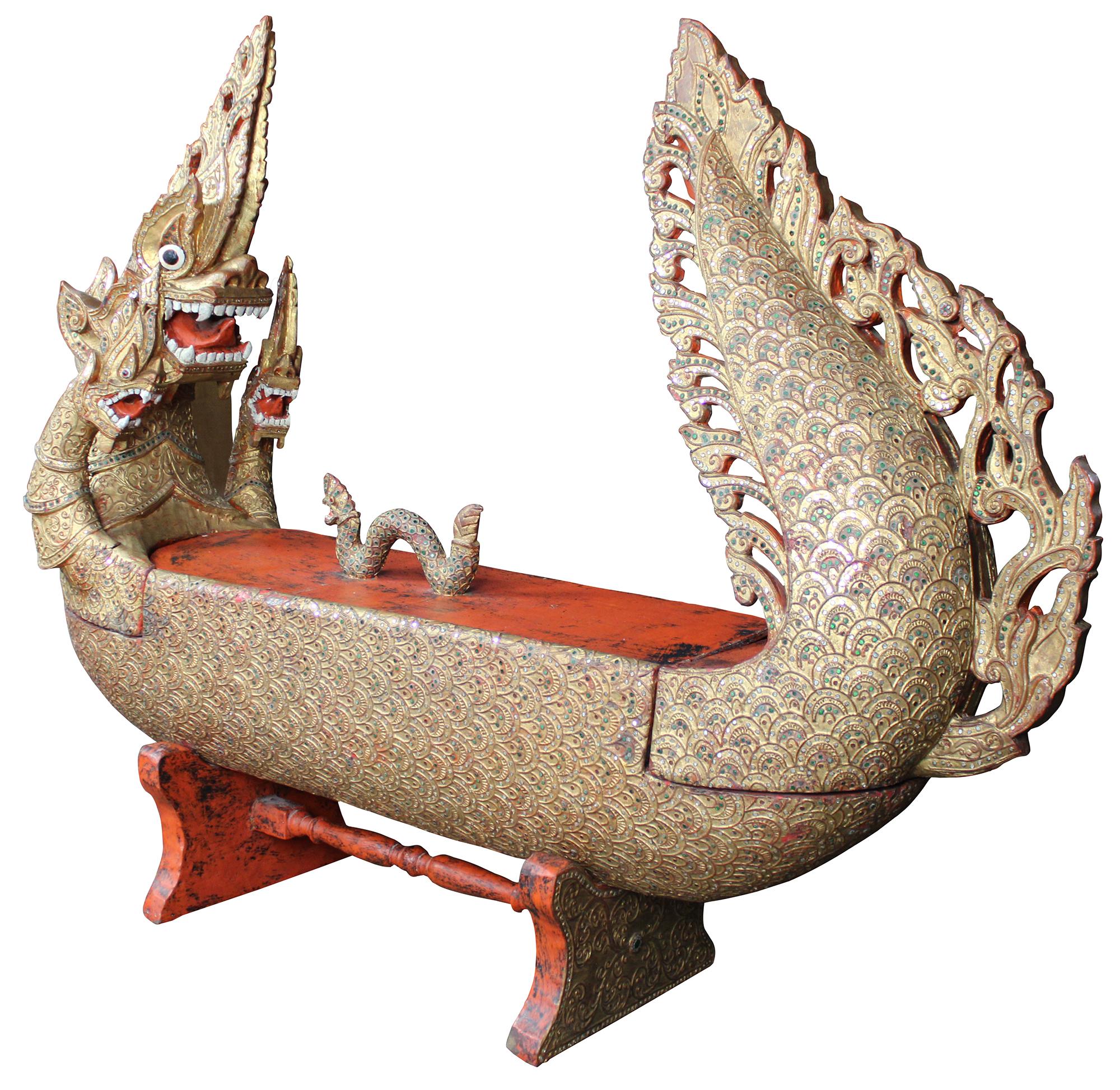 Elaborately carved Burmese Royal Barge boat box. Features red lacquered finish, with gold gilt, embellished with jeweled inserts. Dragon / serpent motif handle lid reveals storage compartment.

Measures: Storage area 8.5