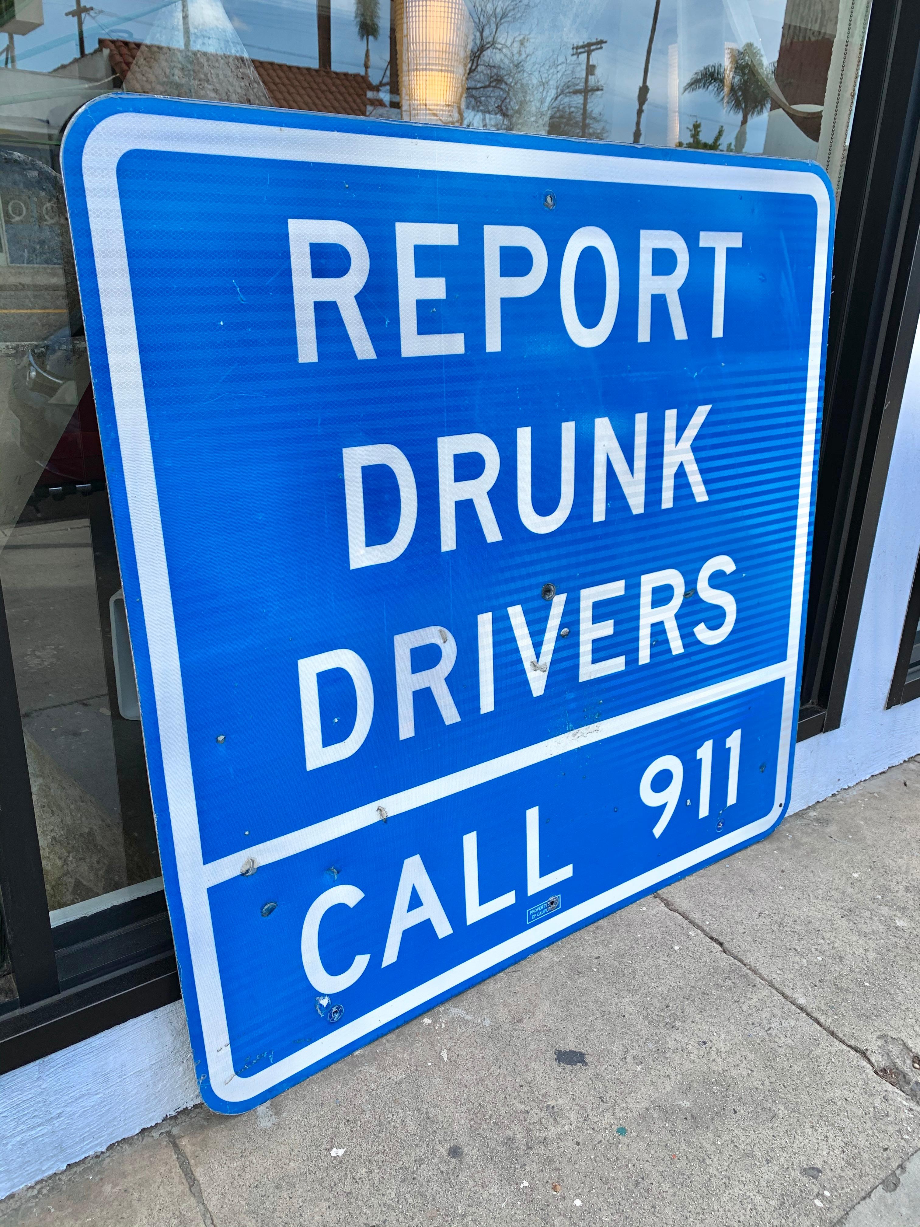 Große Vintage-Autobahn-Schild, das Bericht Drunk Drivers Call 911 liest. Unten gestempelt 