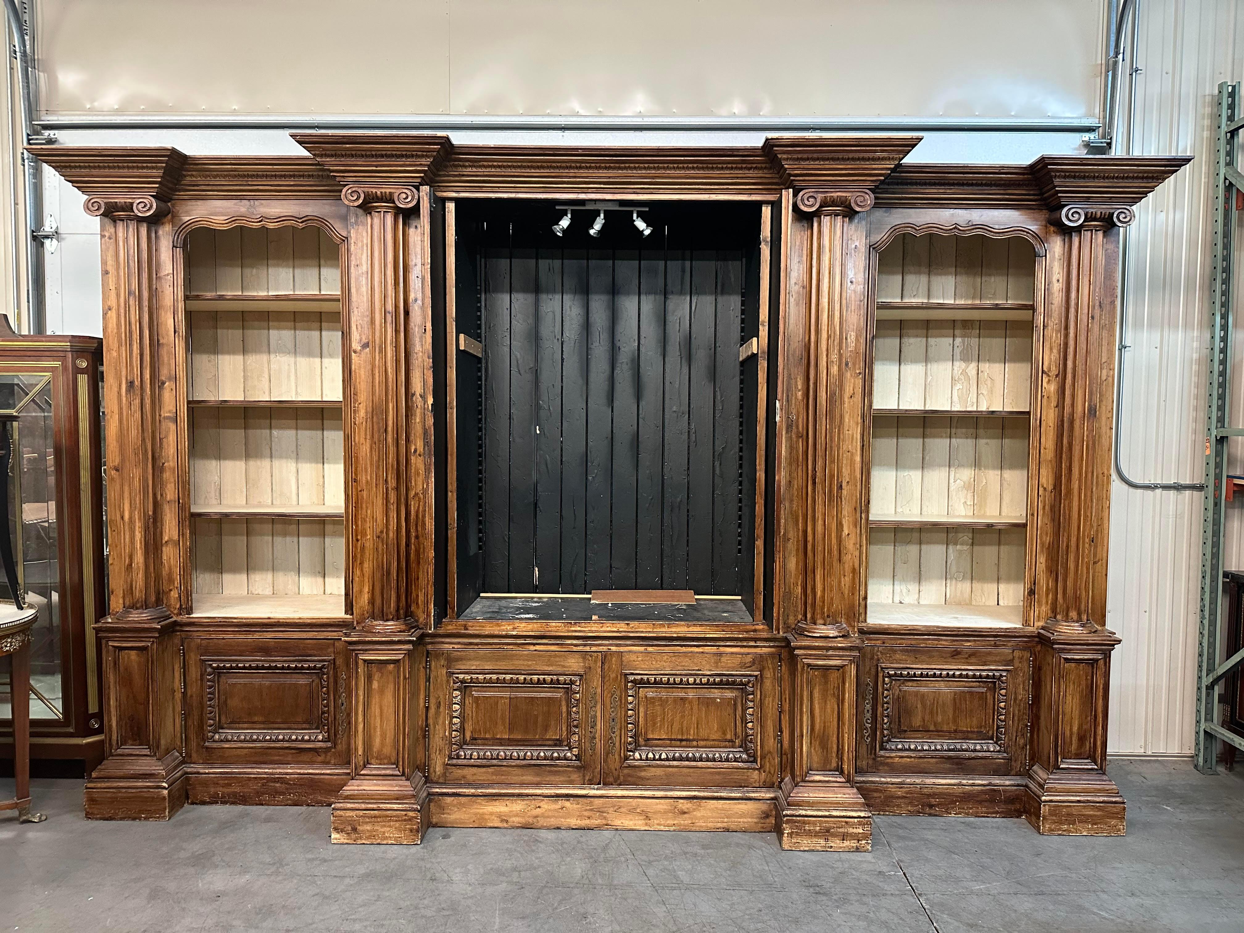 This is a very very unique and rare custom-made English piece. The piece is made of antique elements with all of the charm that antiques have and re-designed to act as an enormous bookcase or entertainment center in the modern age. The piece comes