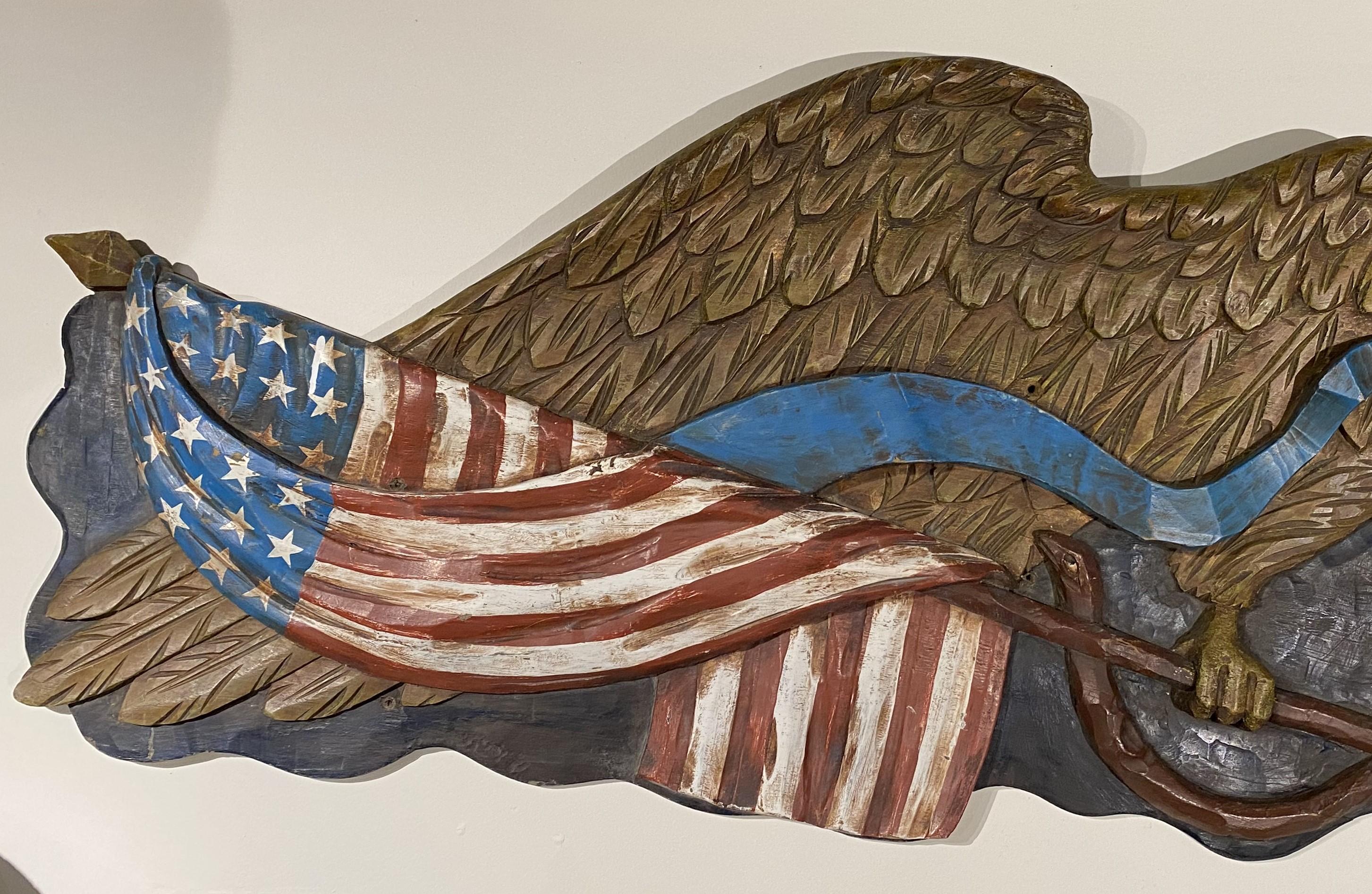 Un'importante targa con aquila meravigliosamente scolpita con bandiera, ramo d'ulivo e nastro blu, opera della Boston Artistic Carving Co. probabilmente risalente alla metà del XX secolo, in condizioni generali molto buone, con una piccola
