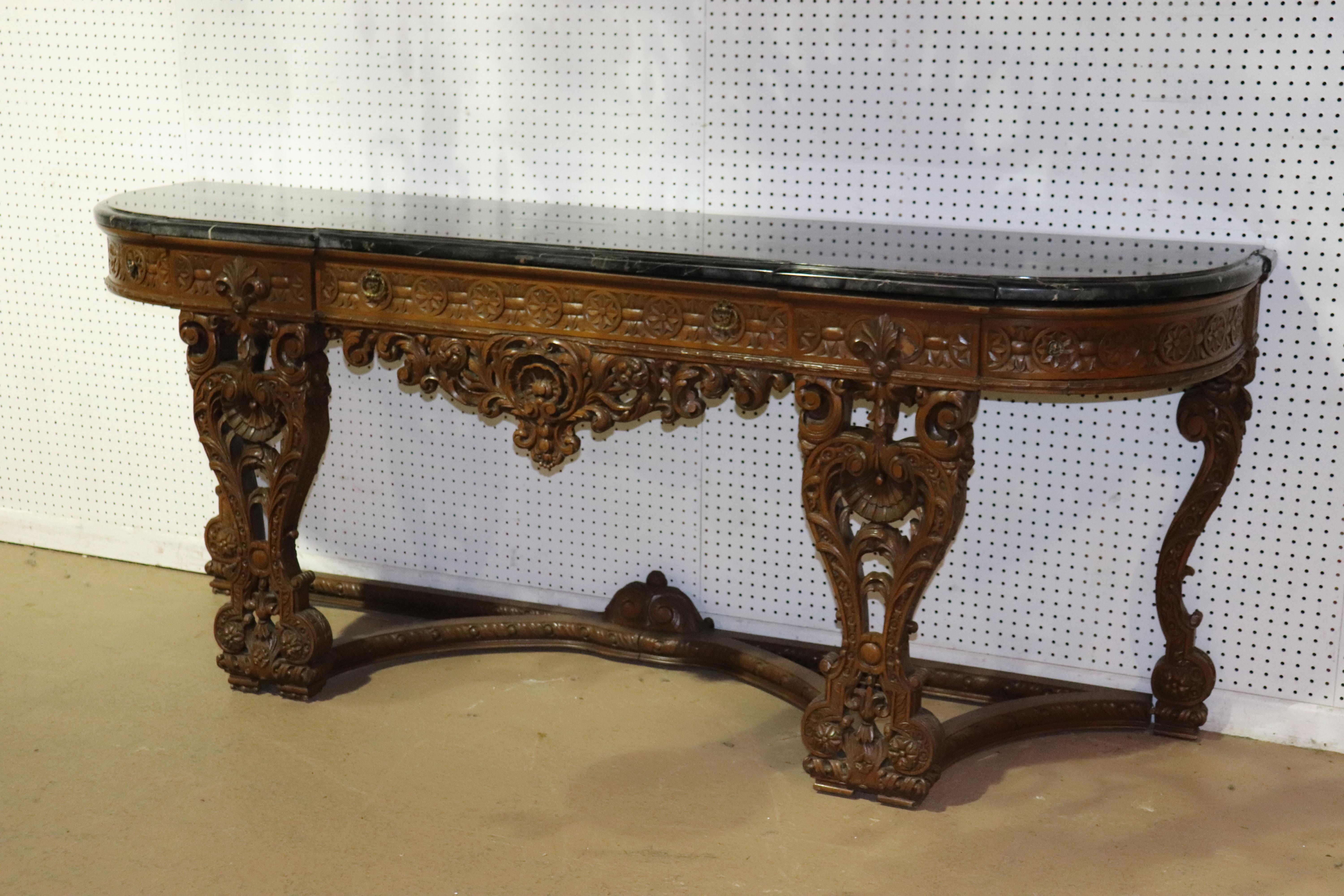 This is a monumental and absolutely stunning black Italian portoro marble top carved walnut sideboard. The sideboard features a wonderful undamaged top and a superb carved frame with 3 drawers. The sideboard measures 89 wide x 23.5 deep x 36 tall.