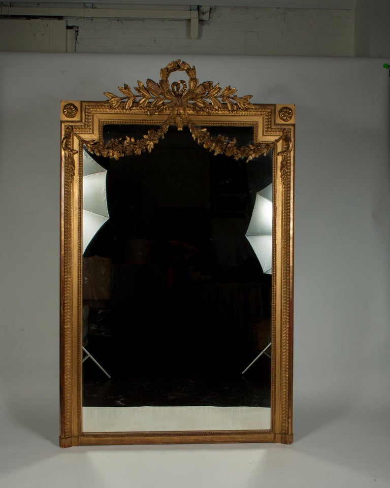 Impressively scaled (over 6 ft!), French gilt wall mirror with beautiful age to the gilt and mirror. Easily completes a room looking for that one large piece. Wonderful condition for it's age.