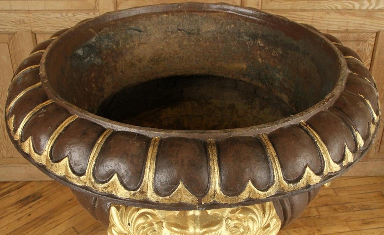 A monumental cast iron garden urn having gold-painted lion masks in relief. Measures: Height 41.5