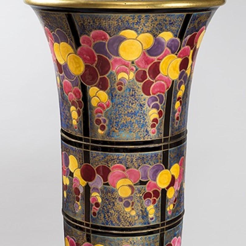 A French ceramic vase by Odette Chatrousse-Heiligenstein. This spectacular and unique tulip shaped vase rests on a circular heel with a polychrome ceramic lapis background. The vase is adorned with fall colors in circles interspersed all over. Circa