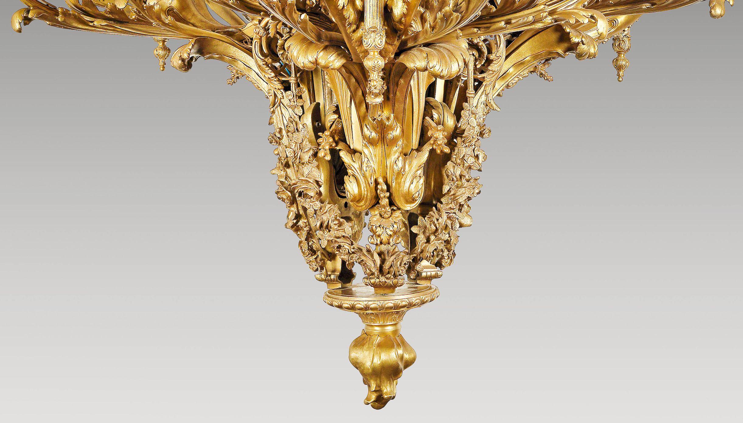Finely chased and gilded bronze. 39-flame electric mounted, bronze frame with main branches in two-stage crown form, each main branch consists of fully-plastic cast, mermaid women facing each other, each holding a seven-flame candelabra, rich floral