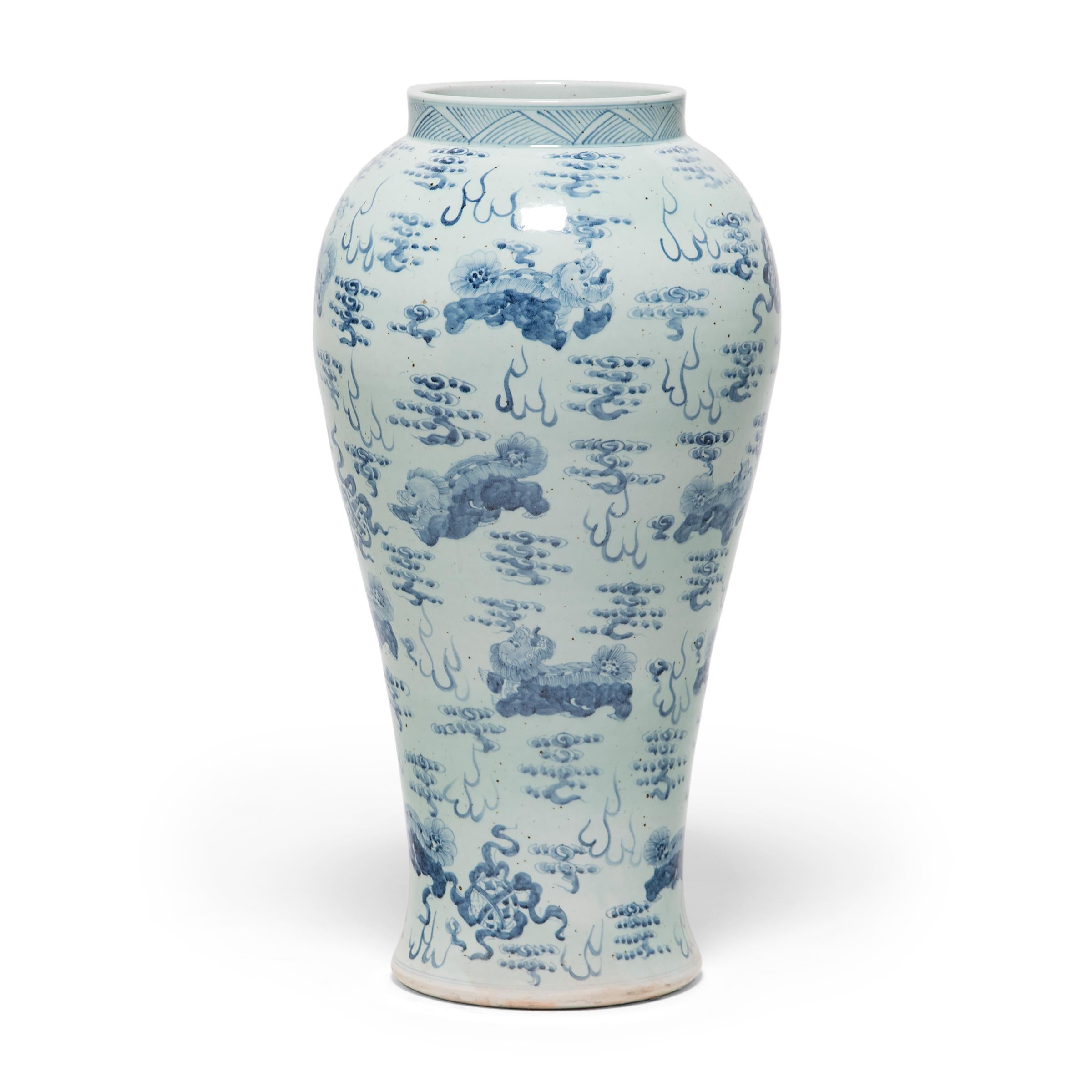 Beautifully rendered with expressive brushwork, the painted decoration on this monumental baluster jar demonstrates the exceptional artistry of Chinese blue-and-white porcelain. Guardian fu lion dogs float amidst celestial clouds, playfully chasing
