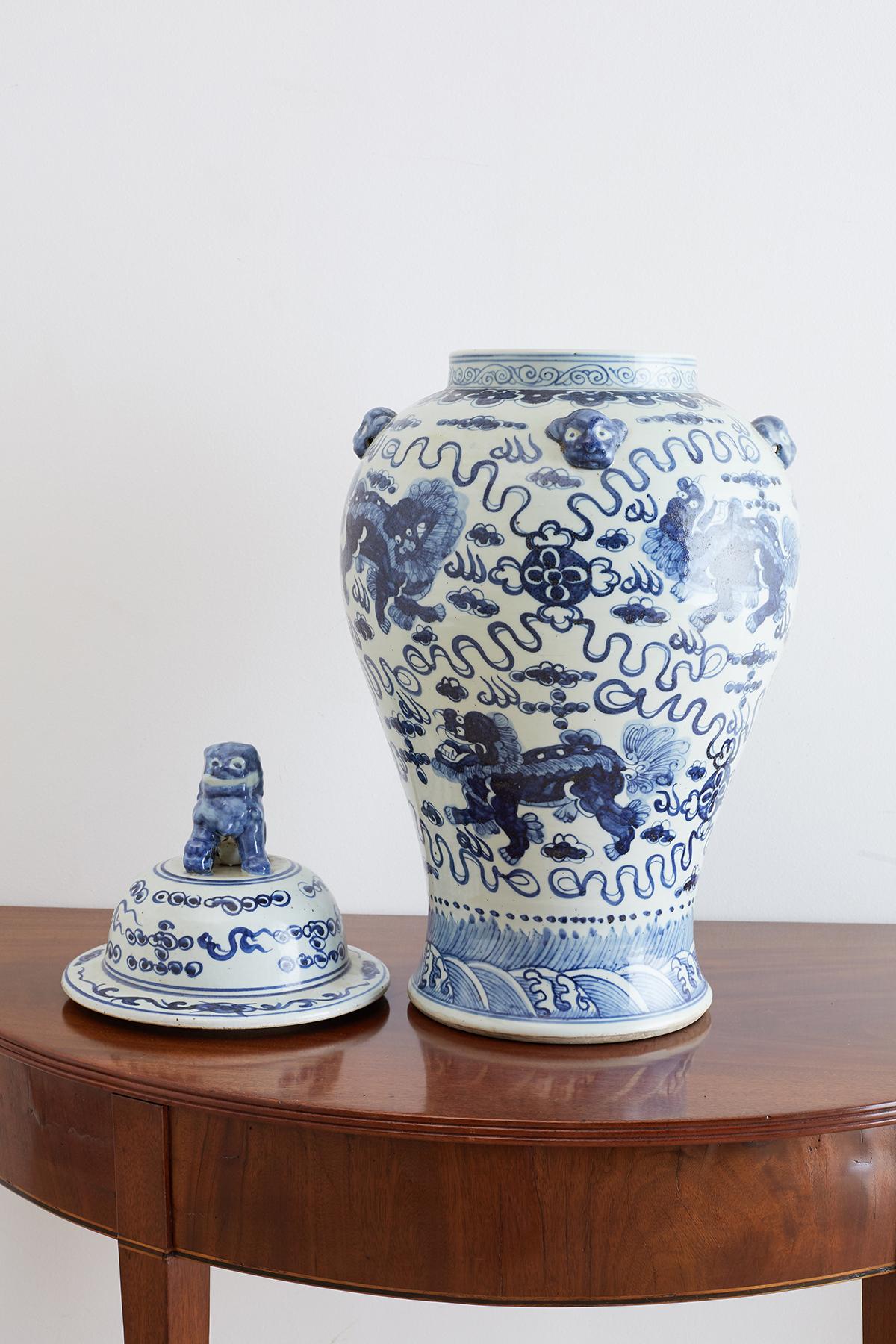 Monumental Chinese blue and white porcelain ginger jar or temple jar. Features hand-painted foo dogs or lions amid the clouds and fire with whimsical designs around them. The beautifully tapered form has mythical beast heads decorating the