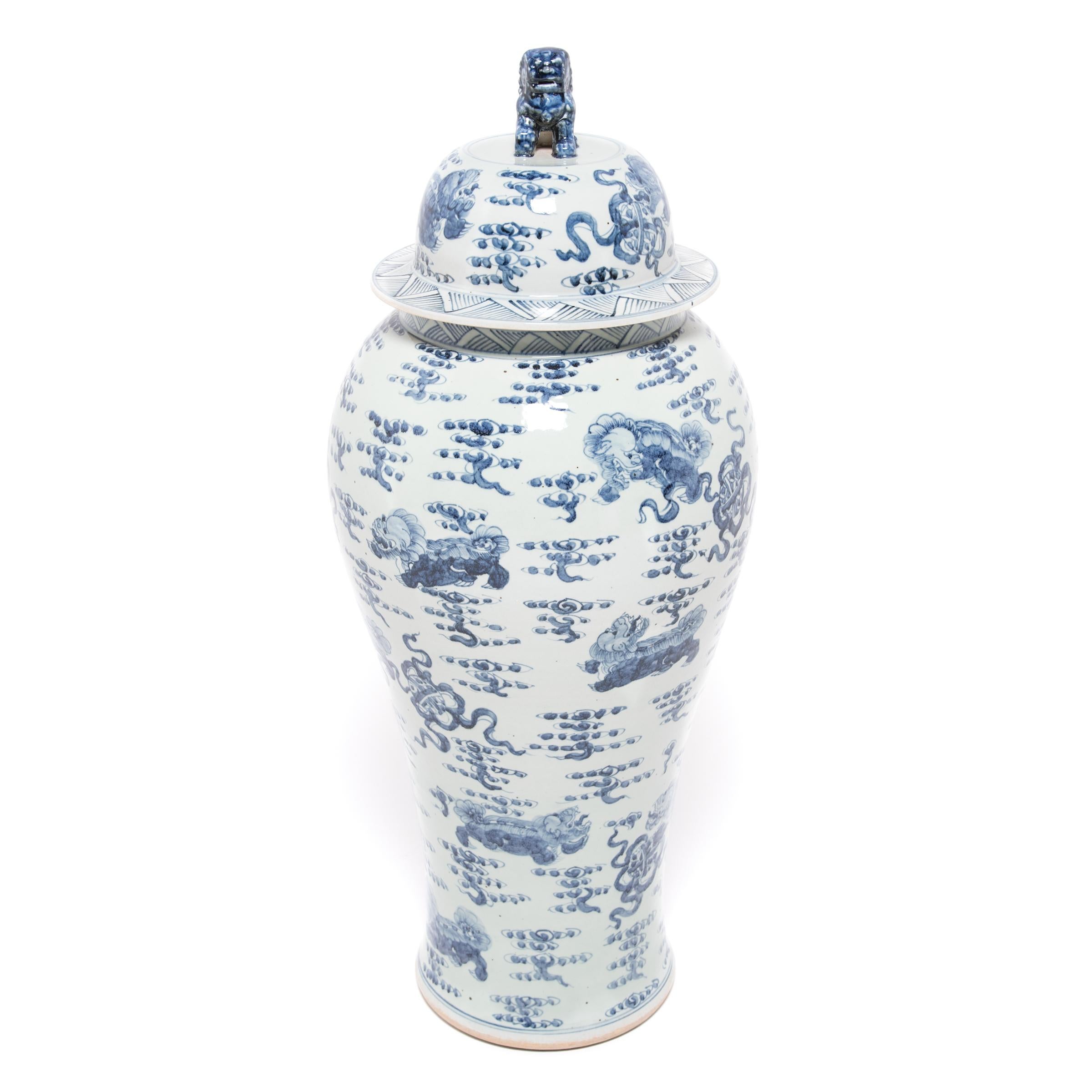 This contemporary monumental blue and white ginger jar is beautifully hand painted with mythical qilin and embroidered balls. As emblems of magnificence and benevolence, the lively qilin soar through the field of clouds with radiant joy. Capping the