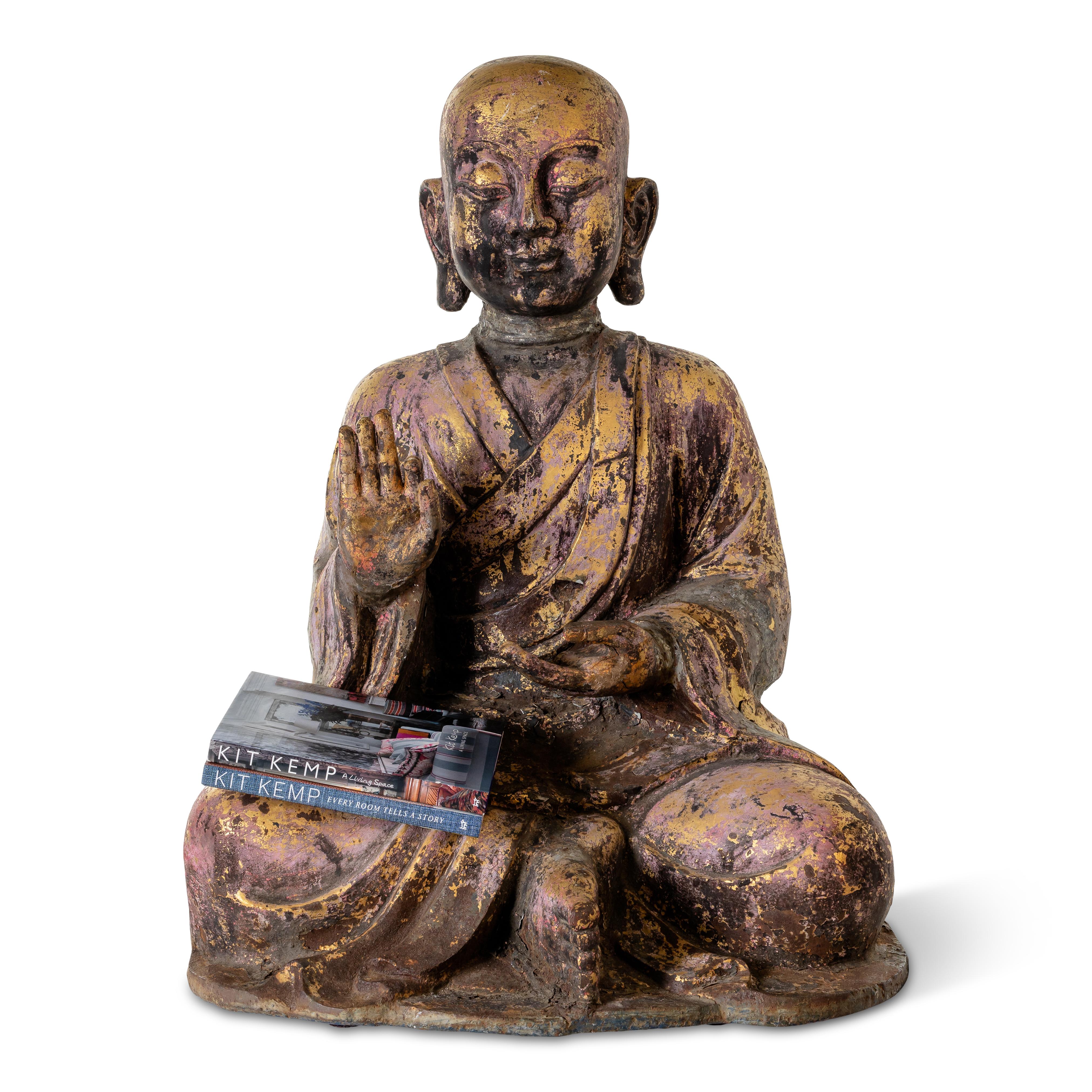 Replica of a large stone Chinese Buddha from the 15th-16th century featuring weathered paint in various colors.