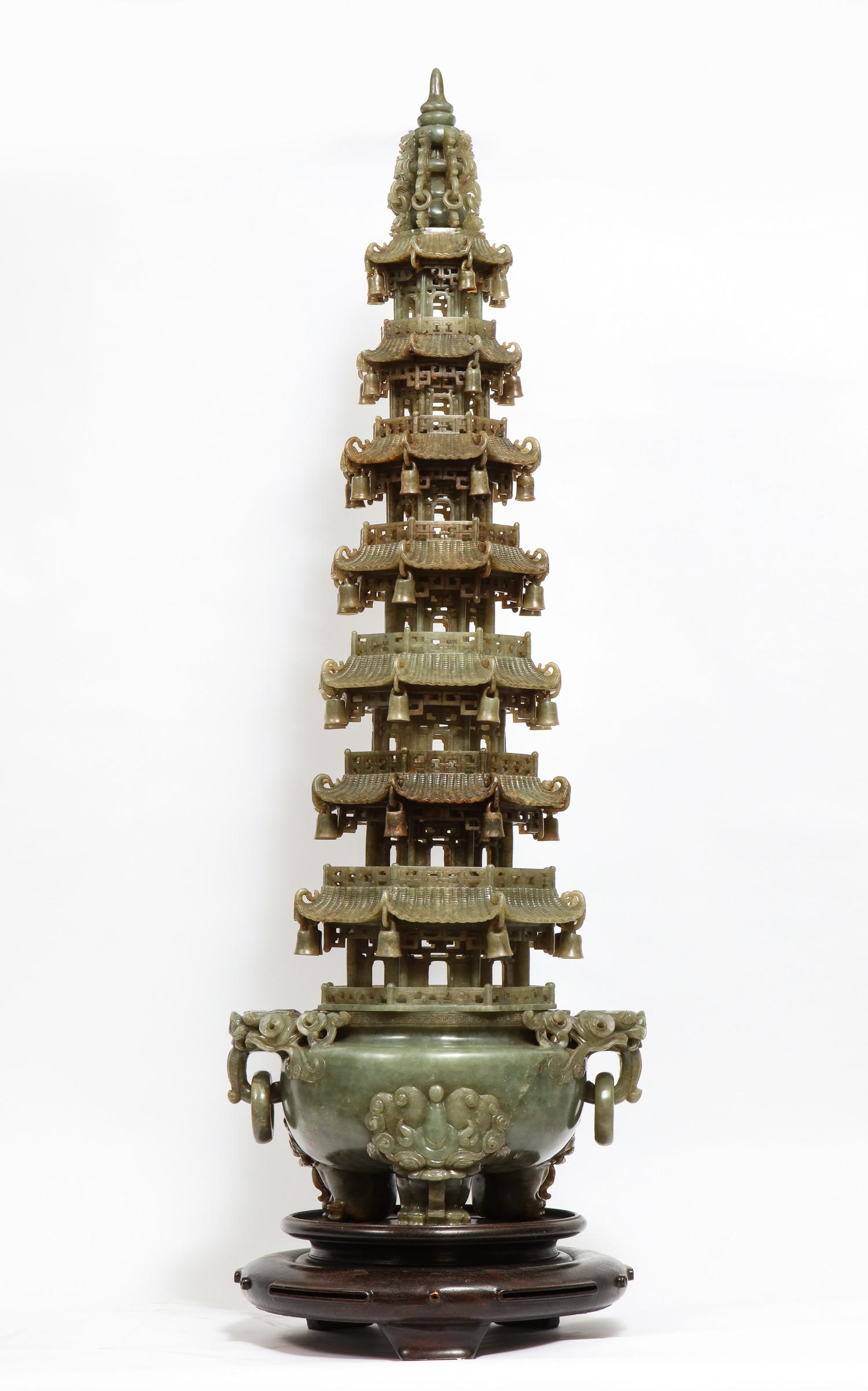 Monumental Chinese serpentine jade carved pagoda censer, early 20th century.

A masterfully carved Chinese serpentine pagoda censer. The base of the tripod censer is set upon lion-headed paw feet. Two loose ring handles hang from the mouths of